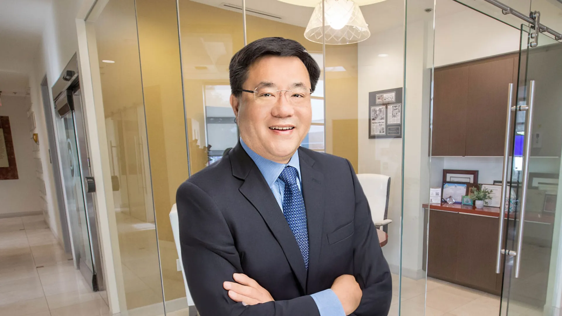 Smiling businessman in a suit stands confidently in a modern office setting, showcasing professionalism.