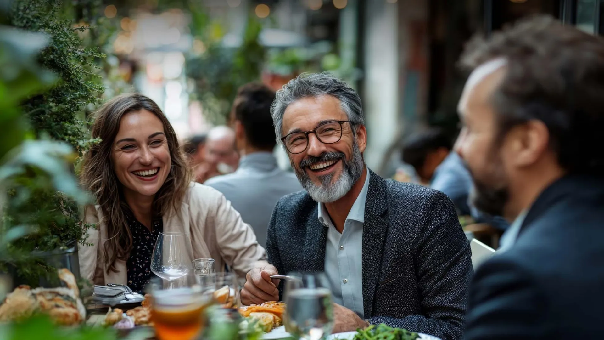 Friends enjoying a lively dinner in a vibrant outdoor restaurant setting.