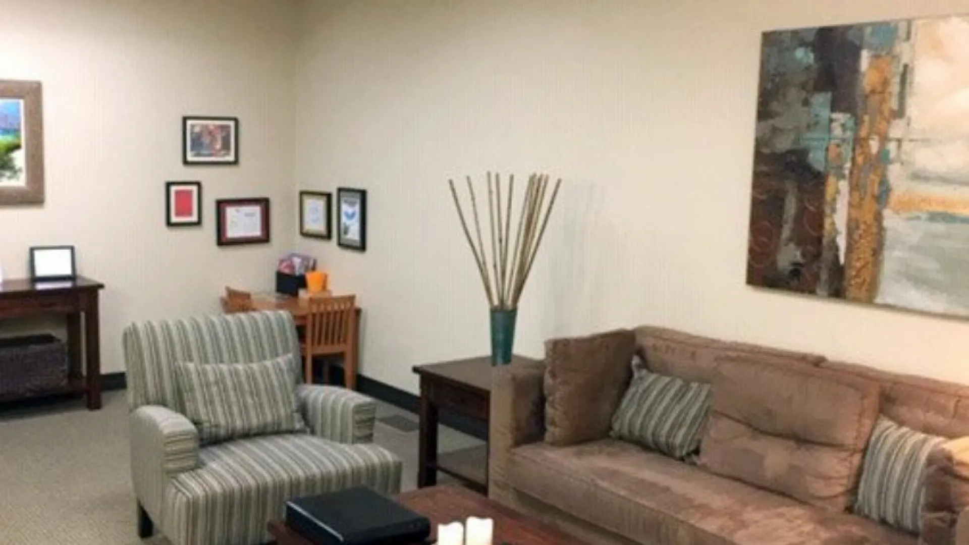 Cozy waiting room with comfortable seating, artwork, and natural decor elements for a calming atmosphere.
