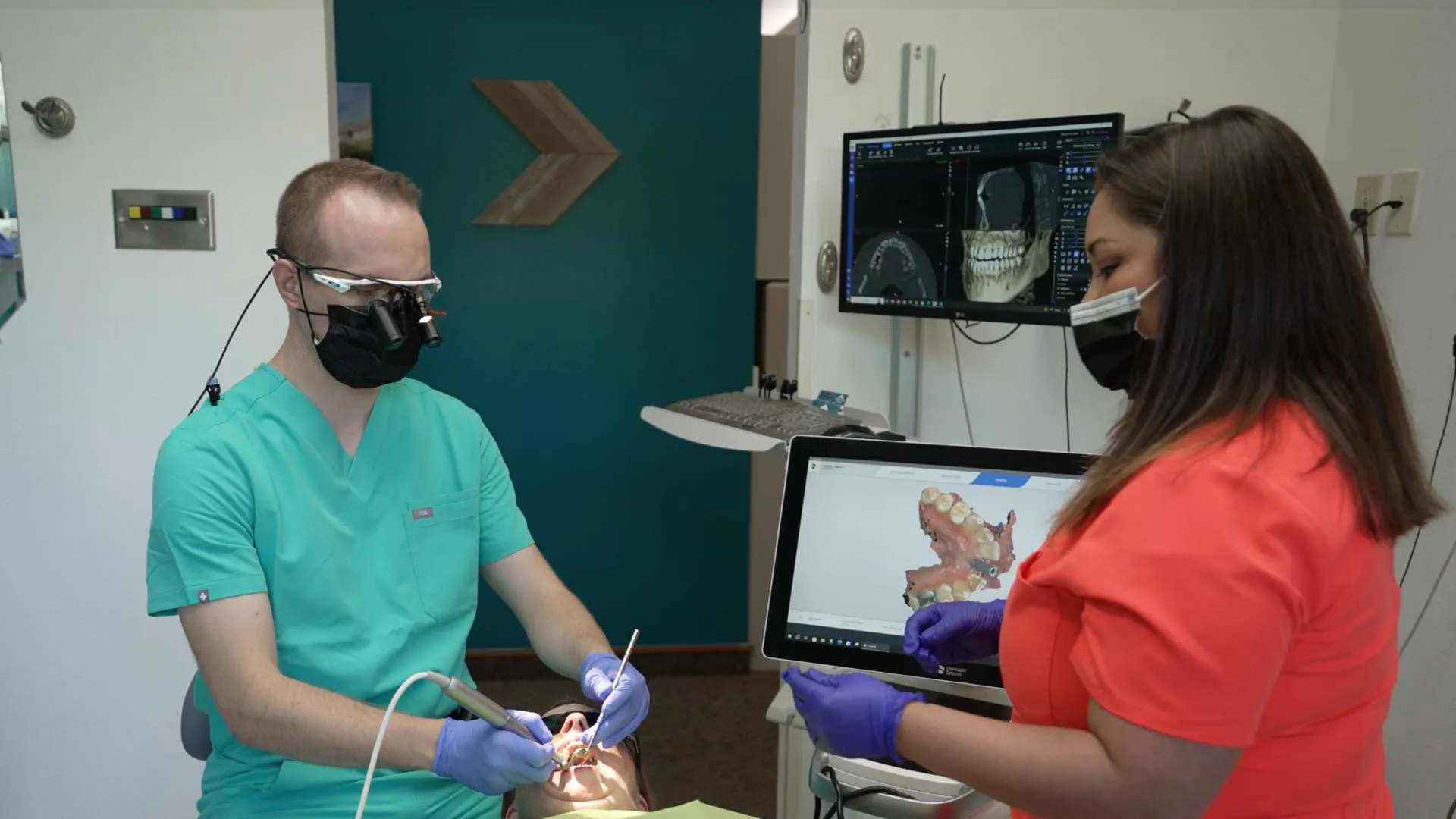 Dentist and assistant using digital dental imaging technology during patient treatment in clinic