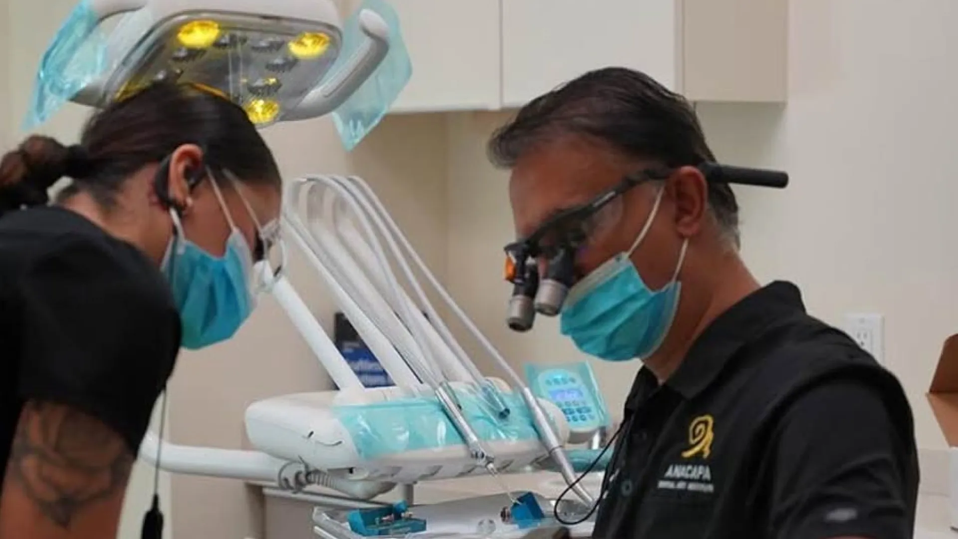 Dentist performing a procedure with an assistant in a modern dental office.