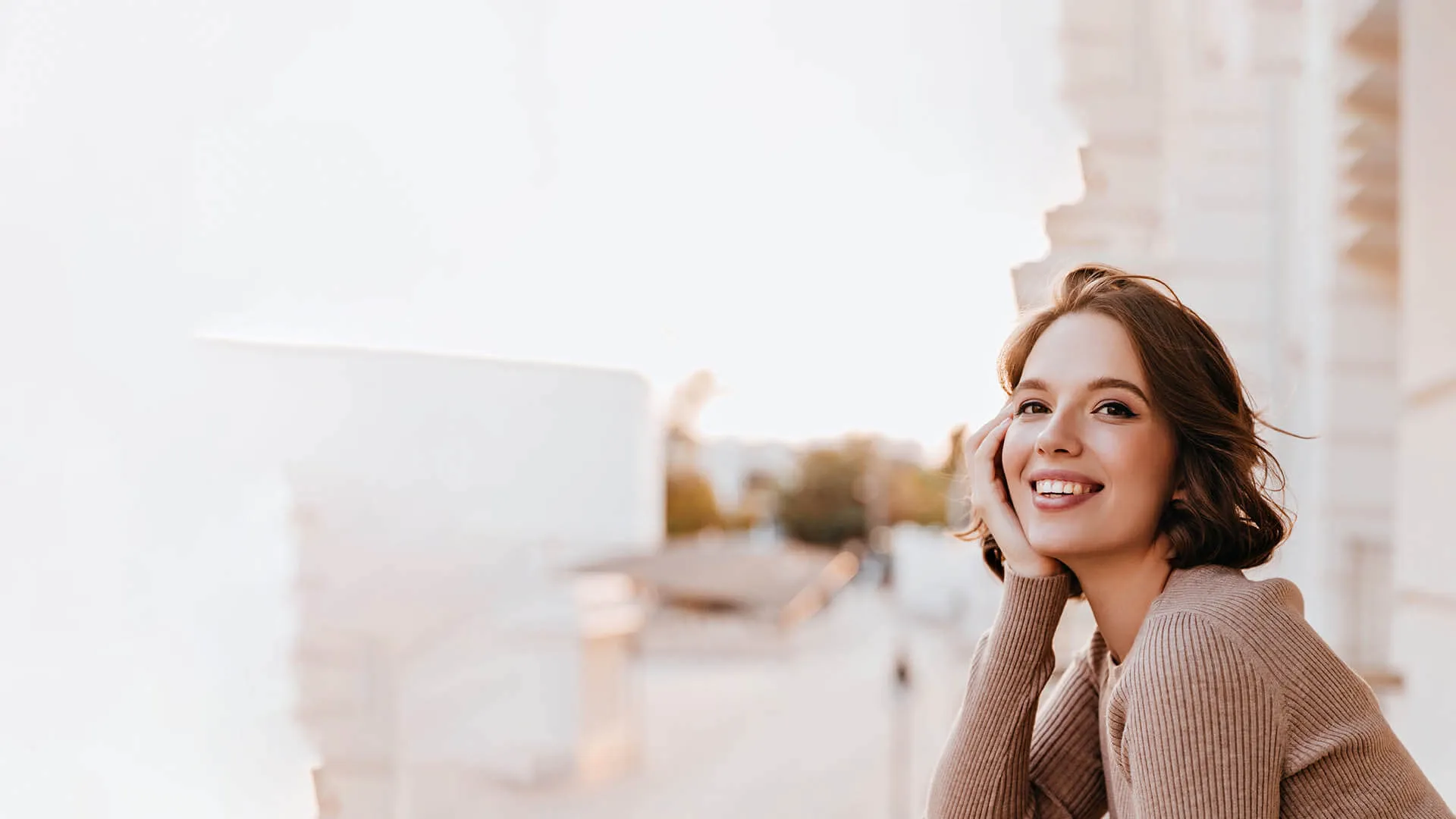a woman smiling with her hand on her face
