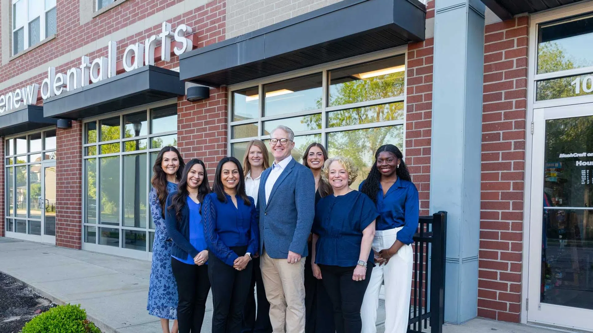 Group of dental professionals standing outside Renew Dental Arts office smiling at camera