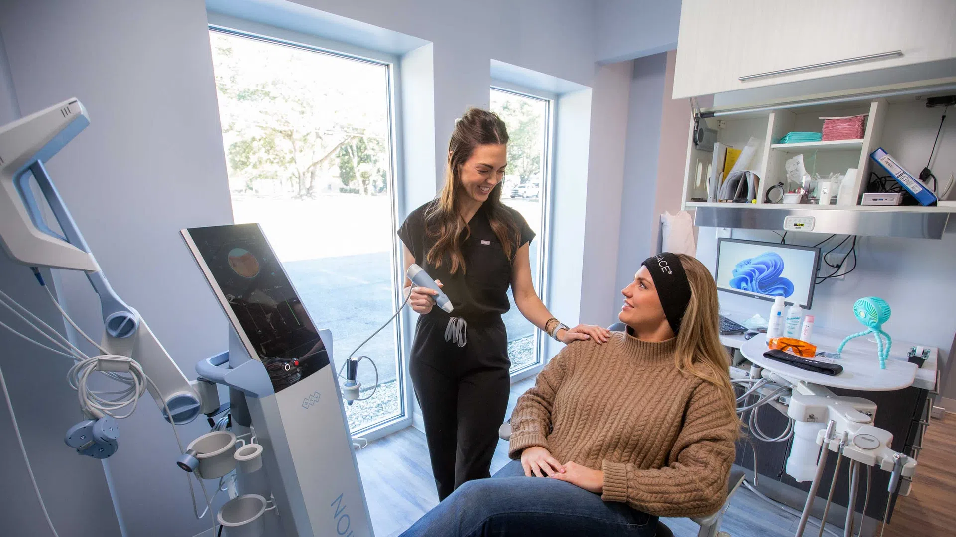 Dentist consultation with patient in modern dental clinic featuring advanced dental equipment and natural light.