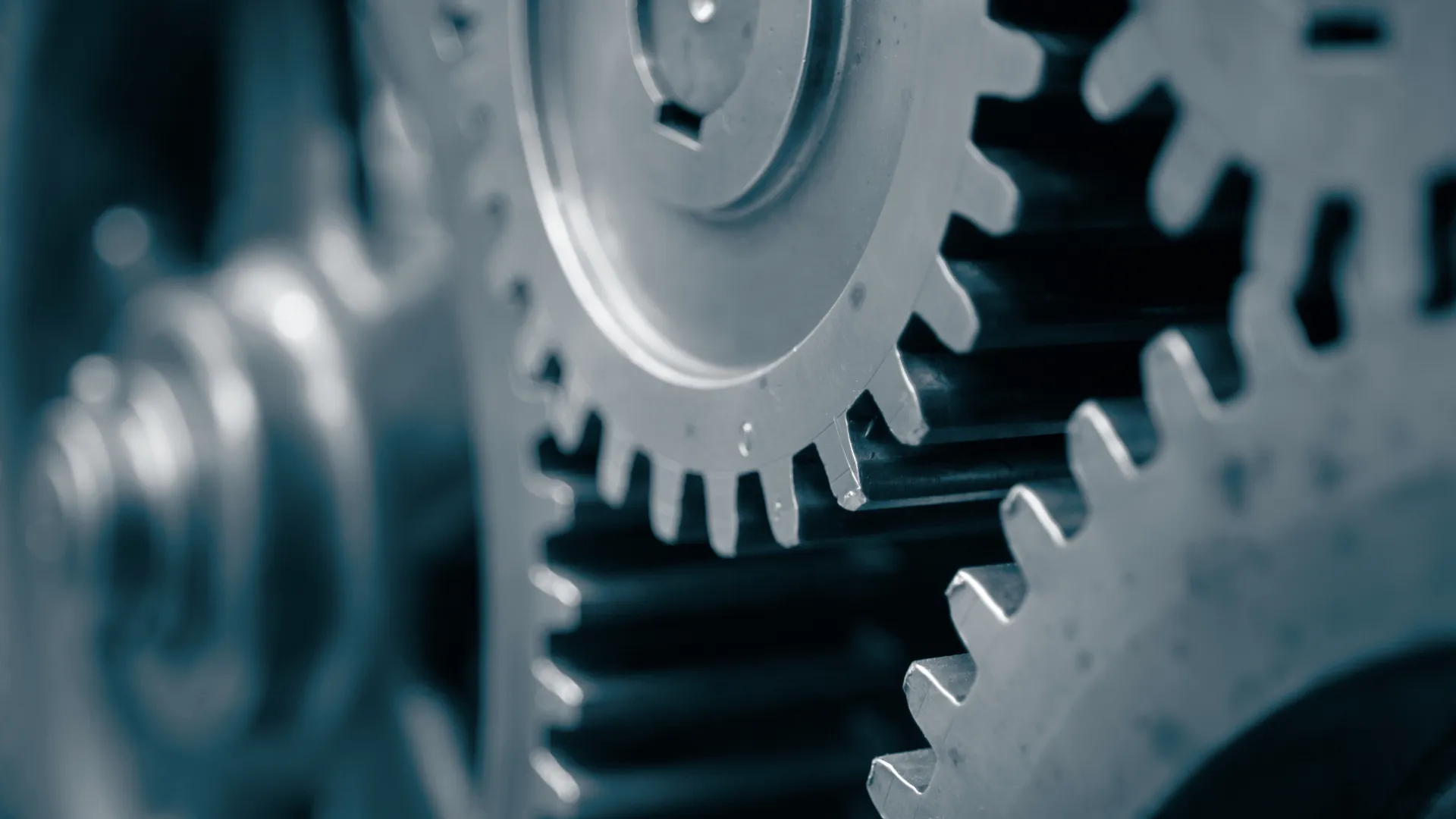 Close-up of interlocking metallic gears in a machine showing detailed teeth and textured surfaces