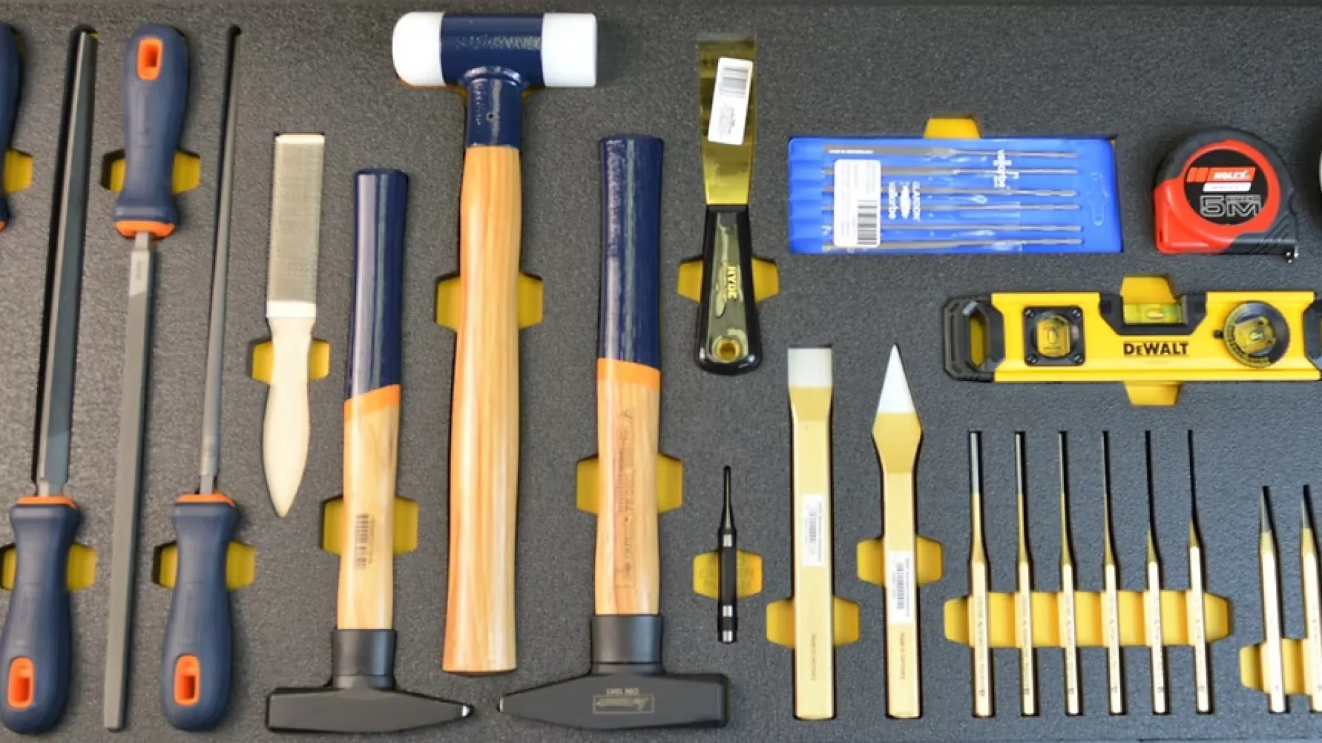 Set of woodworking and measuring tools including chisels, hammers, files, tape measure, level, and magnetic parts tray.