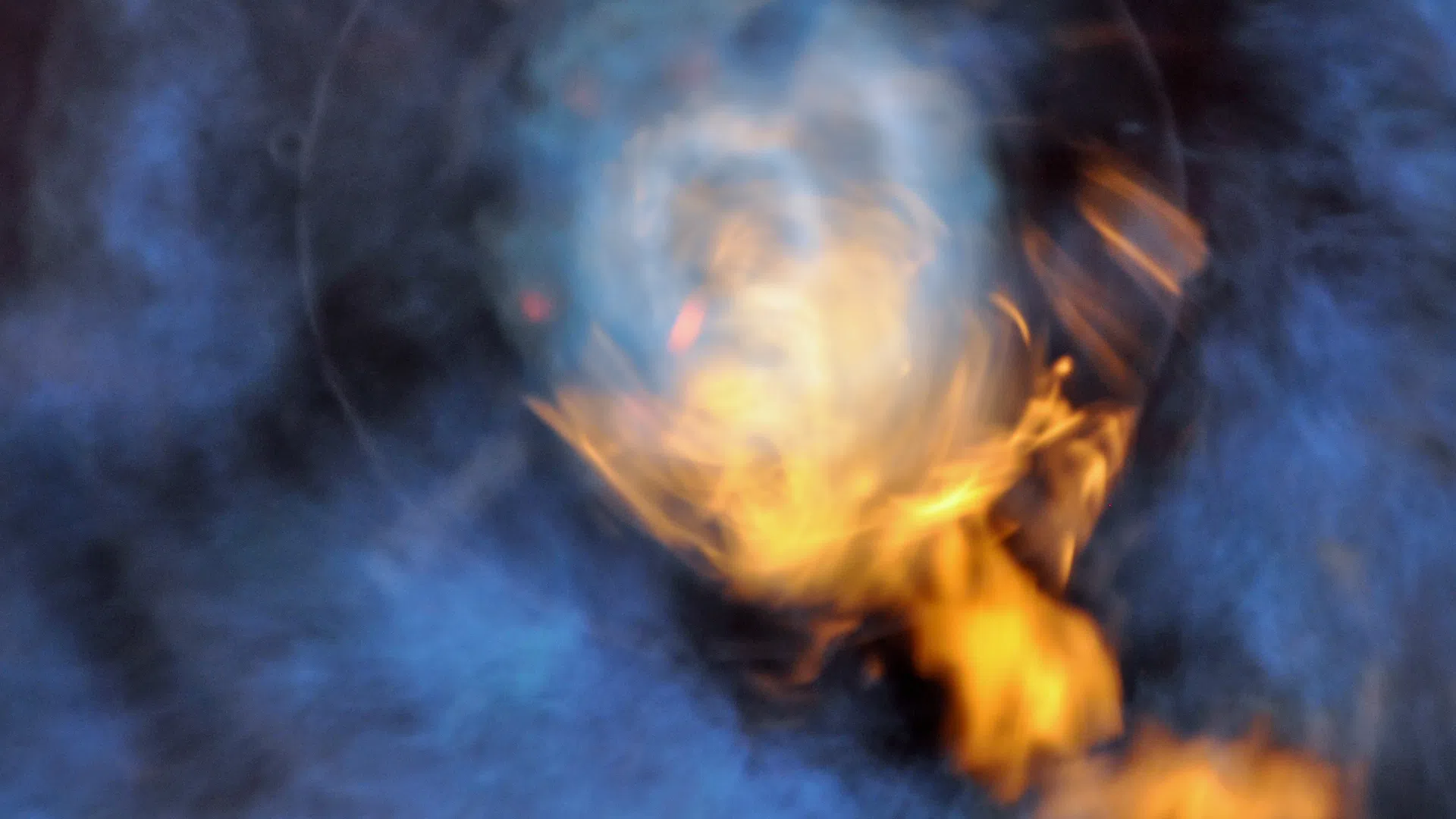 Abstract image of blue smoke and swirling orange flames creating a mysterious fiery effect.