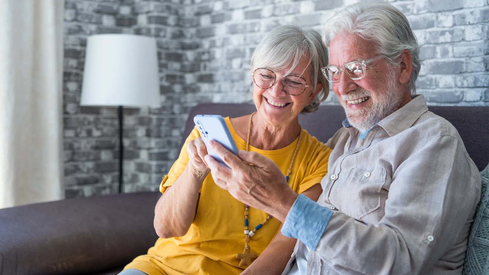 a man and woman sitting on a couch and smiling