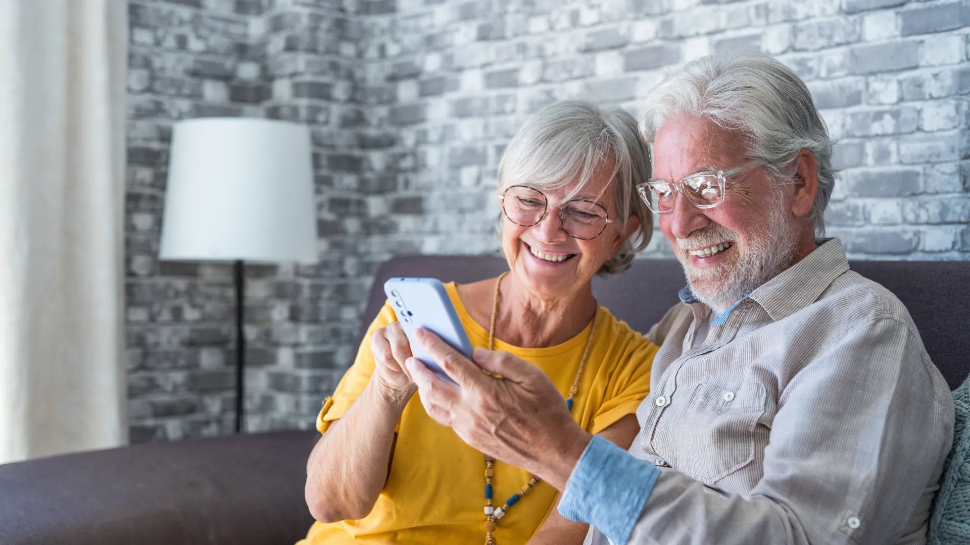 a man and woman sitting on a couch and smiling