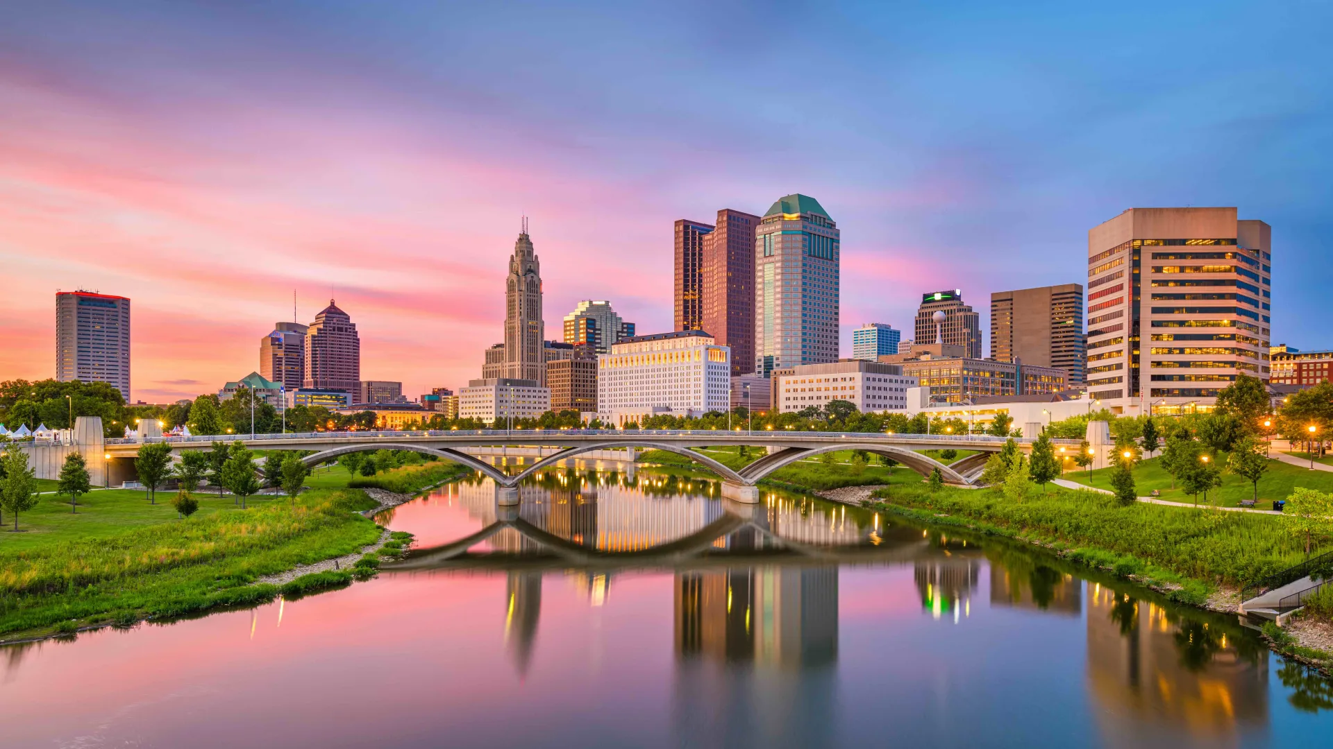 a bridge over a river with a city in the background