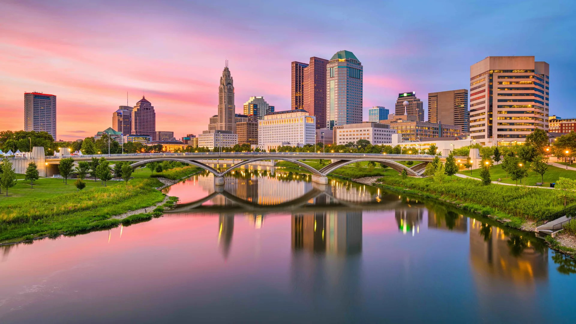 a bridge over a river with a city in the background