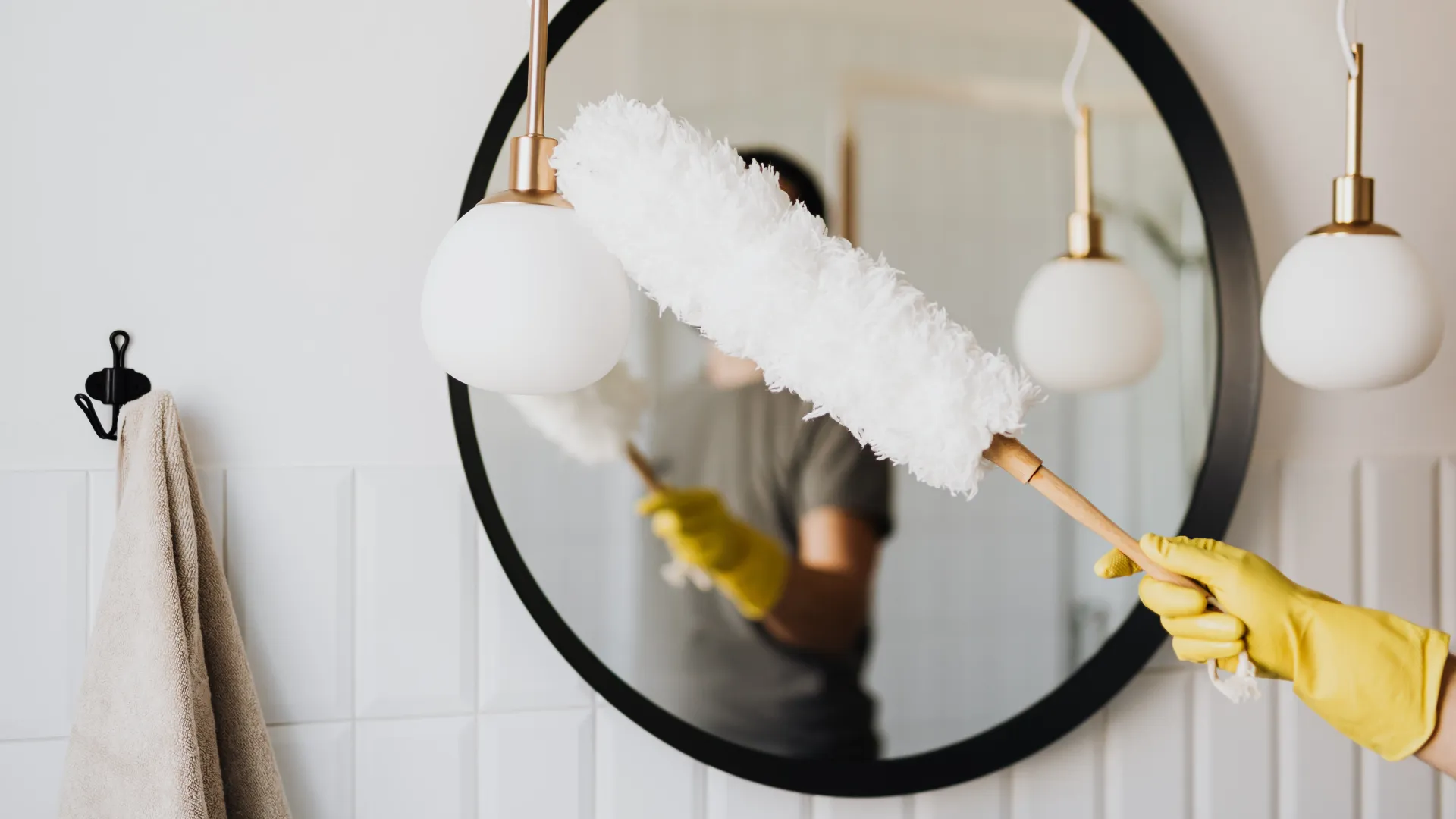 woman cleaning bathroom with duster