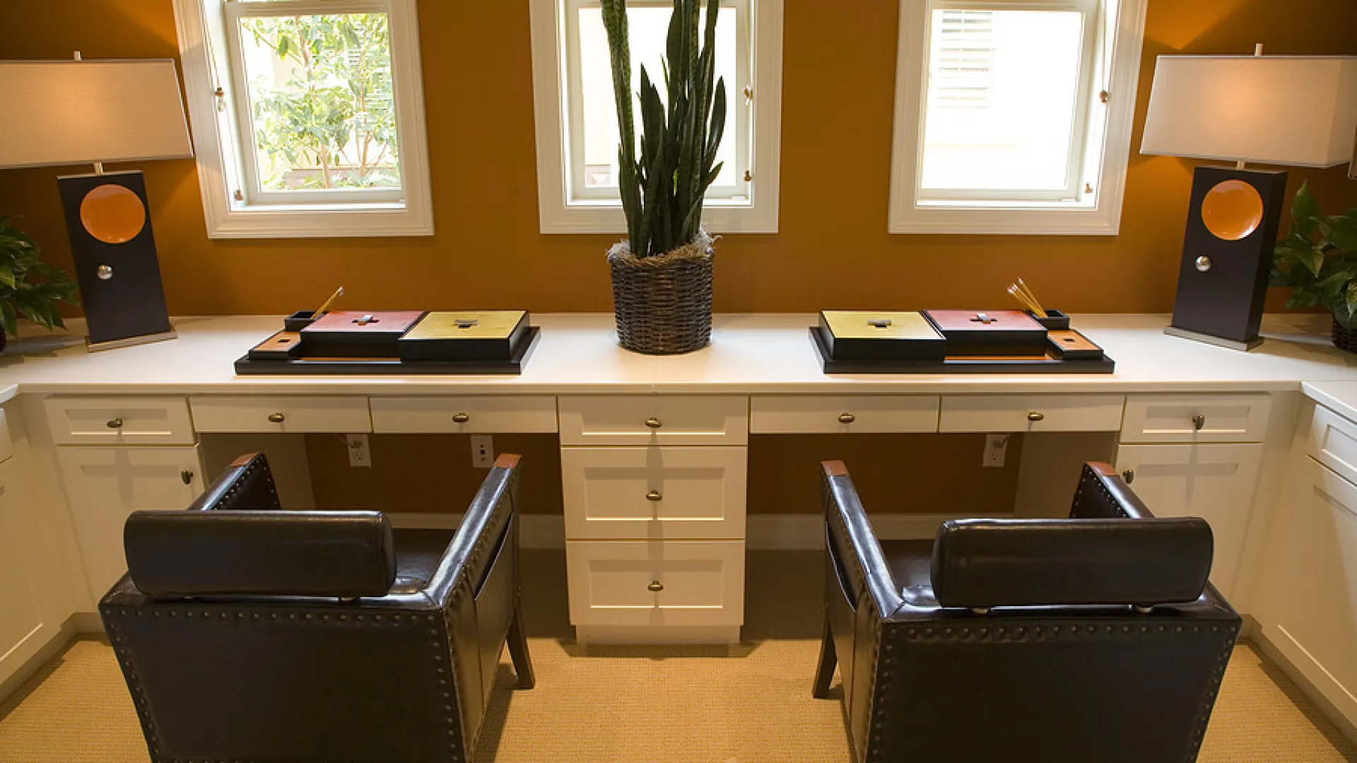 a desk with a chair and a chair in front of a window