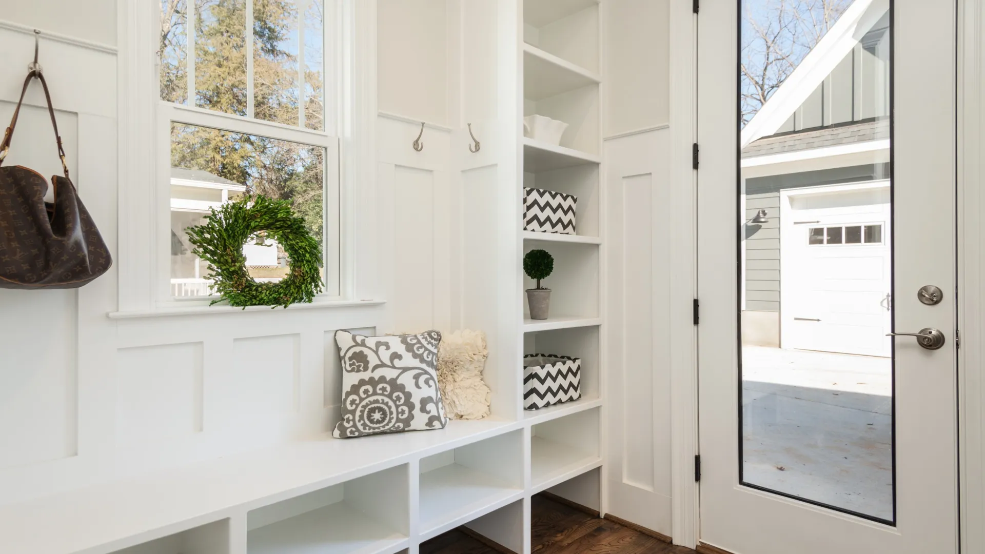 a mudroom painted white with a handbag hanging on a hook