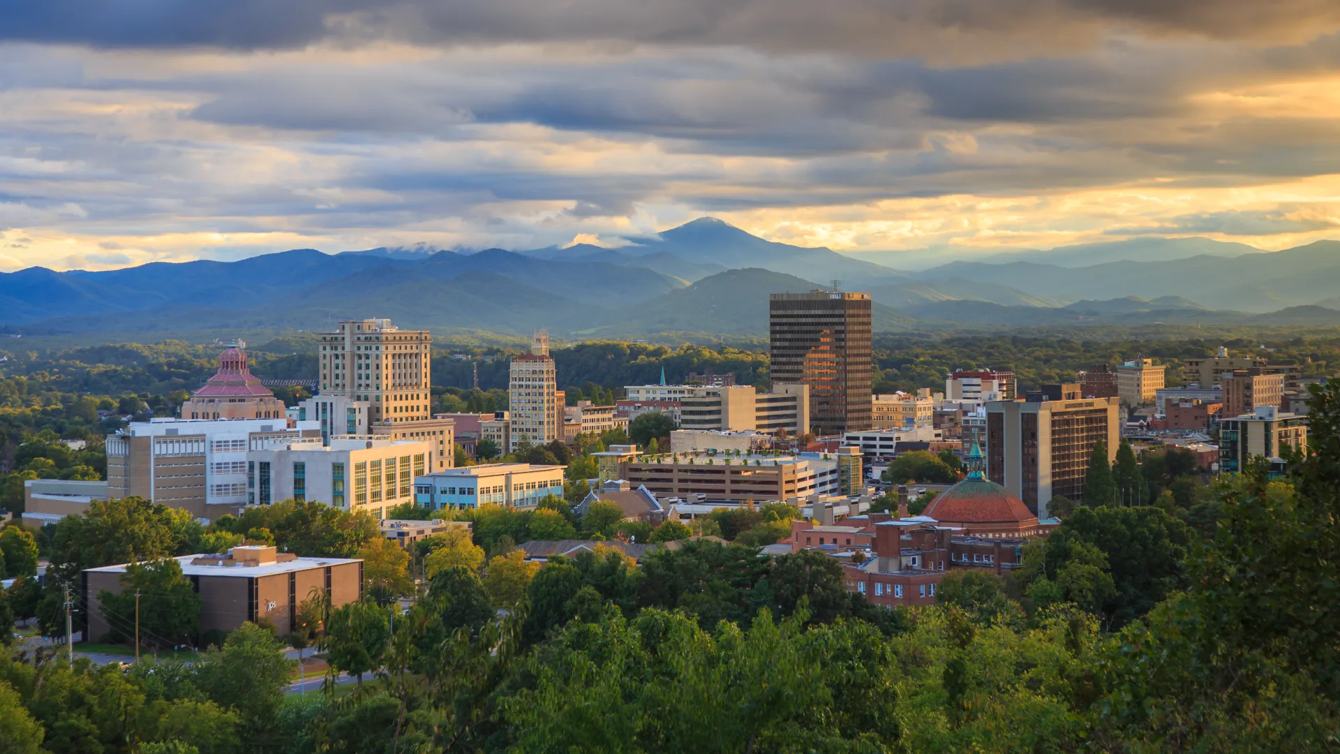 a city with trees and mountains in the background