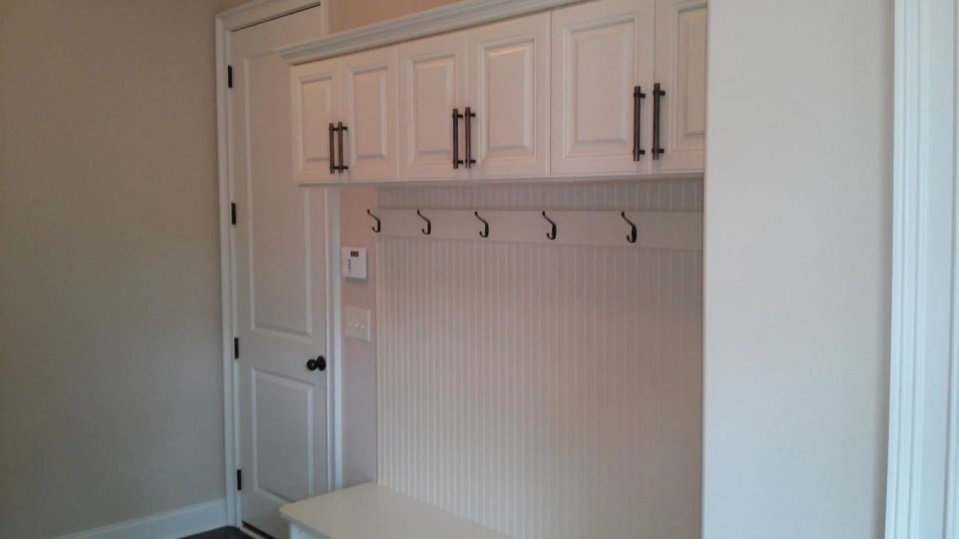 a white cabinet with black handles