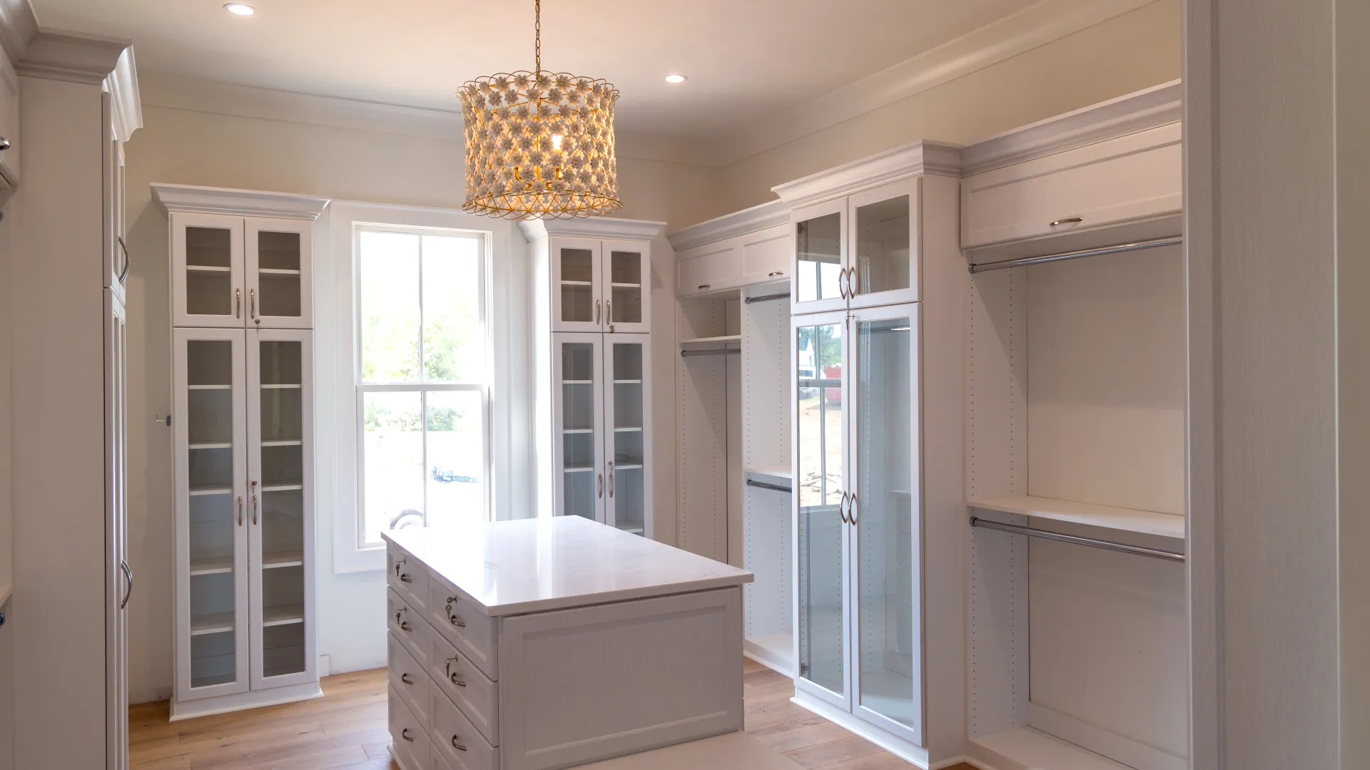 a room with white cabinets and a chandelier