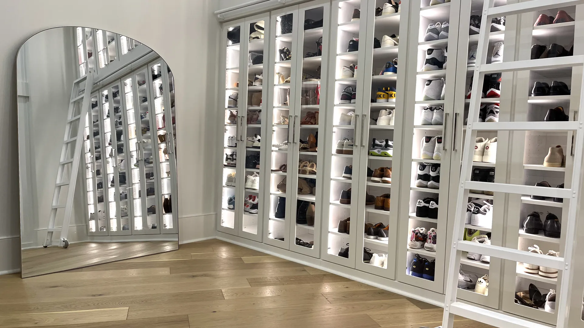 a white shelving unit with many bottles of perfume