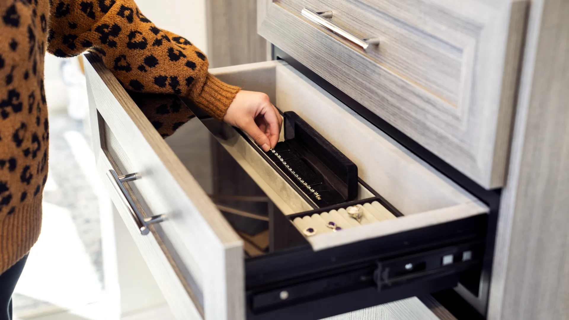 a person opening a safe inside a custom closet drawer