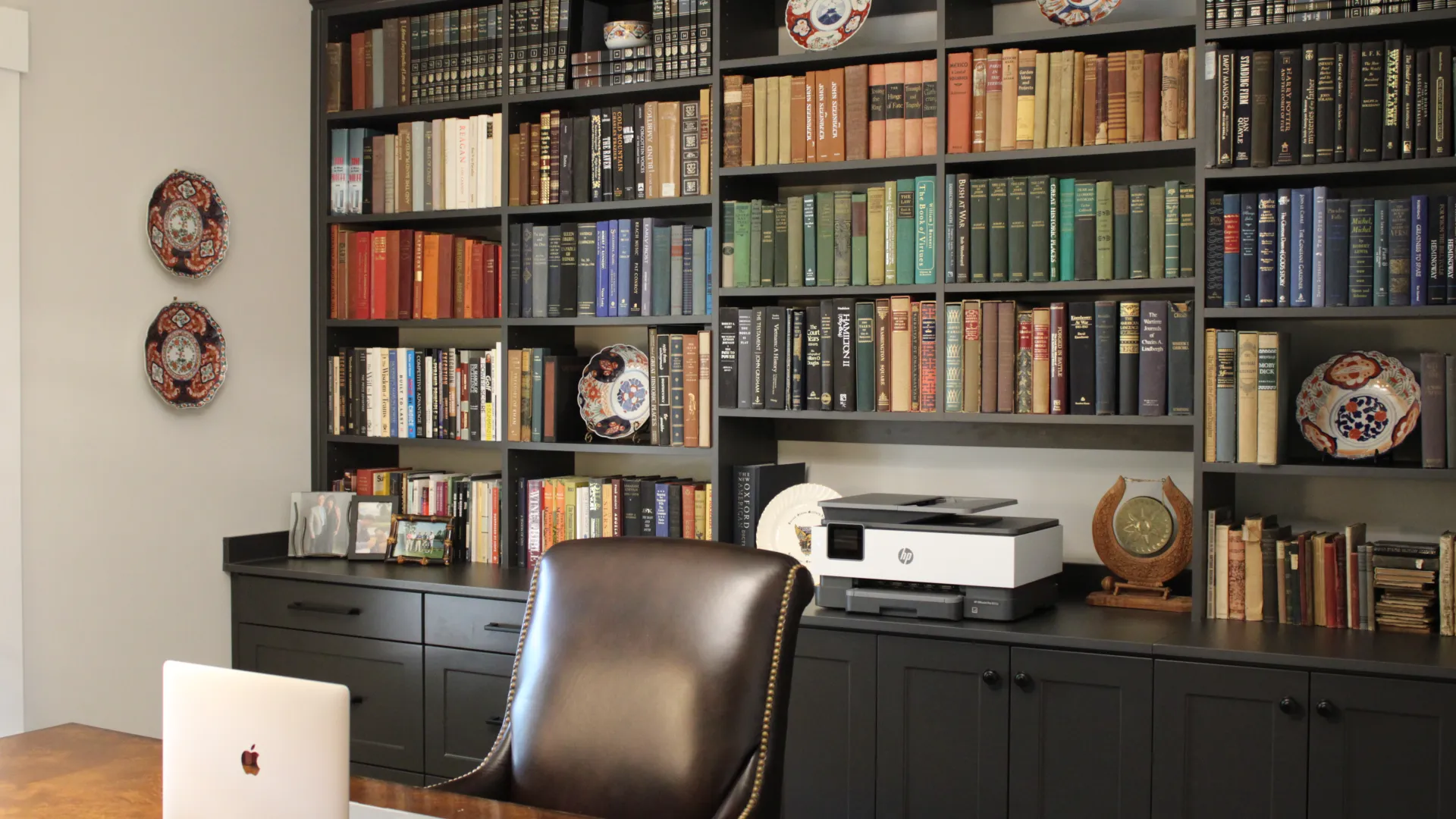 a laptop on a table in front of a bookshelf