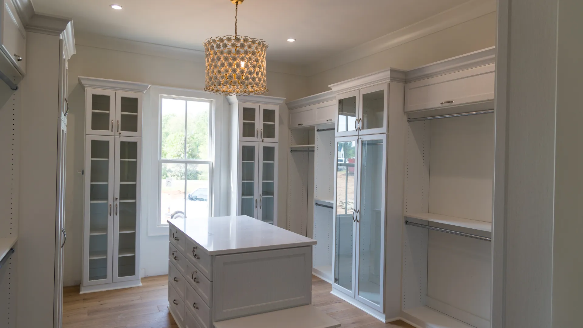 a room with white cabinets and a chandelier