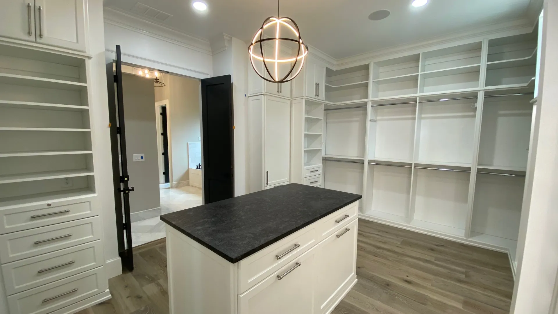 a white closet with a chair and a shelf with objects on it