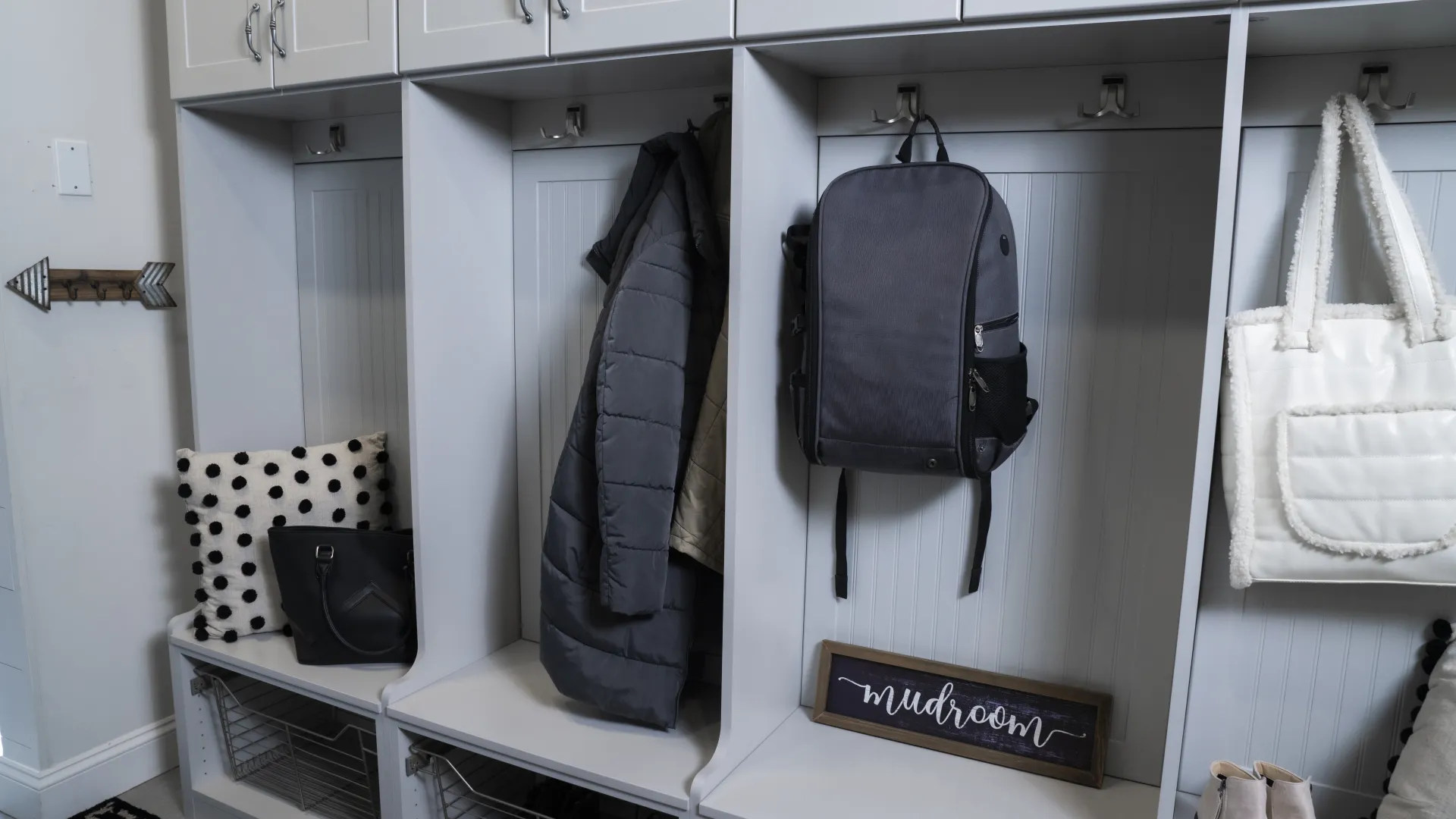 a mudroom with a variety of coats, bags, and backpacks