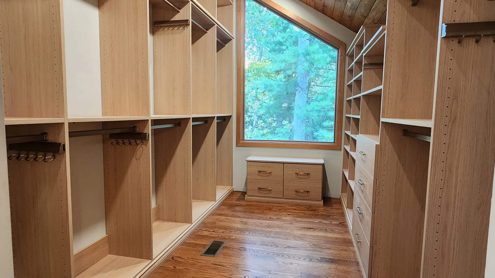 a custom closet with a wood floor and a window