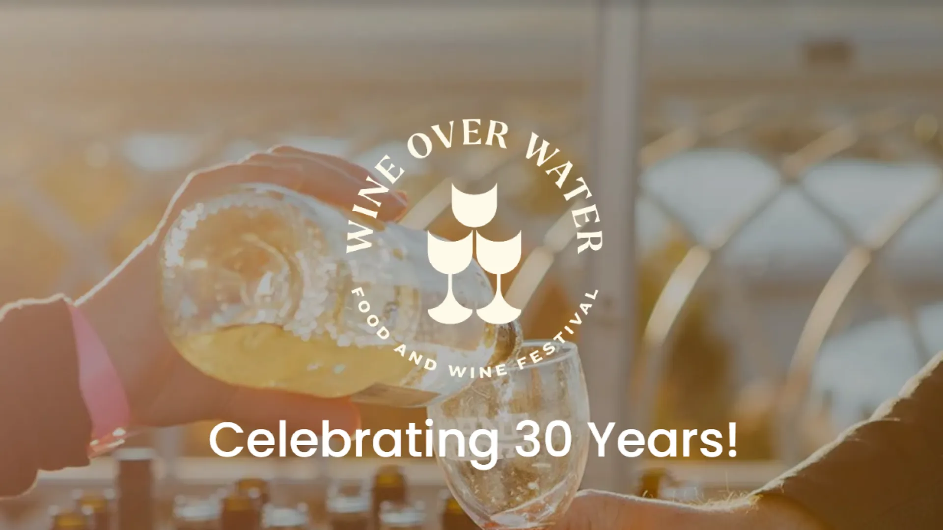 A person pouring white wine from a bottle into a glass for the Chattanooga Wine Over Water Festival in its 30th year