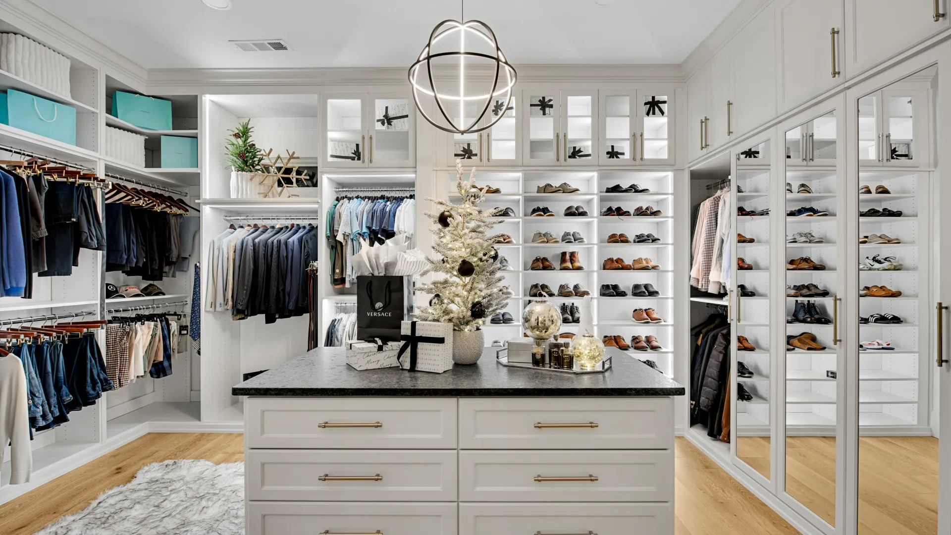 Stylish walk-in closet featuring organized clothing, shoes, and a festive Christmas tree centerpiece.