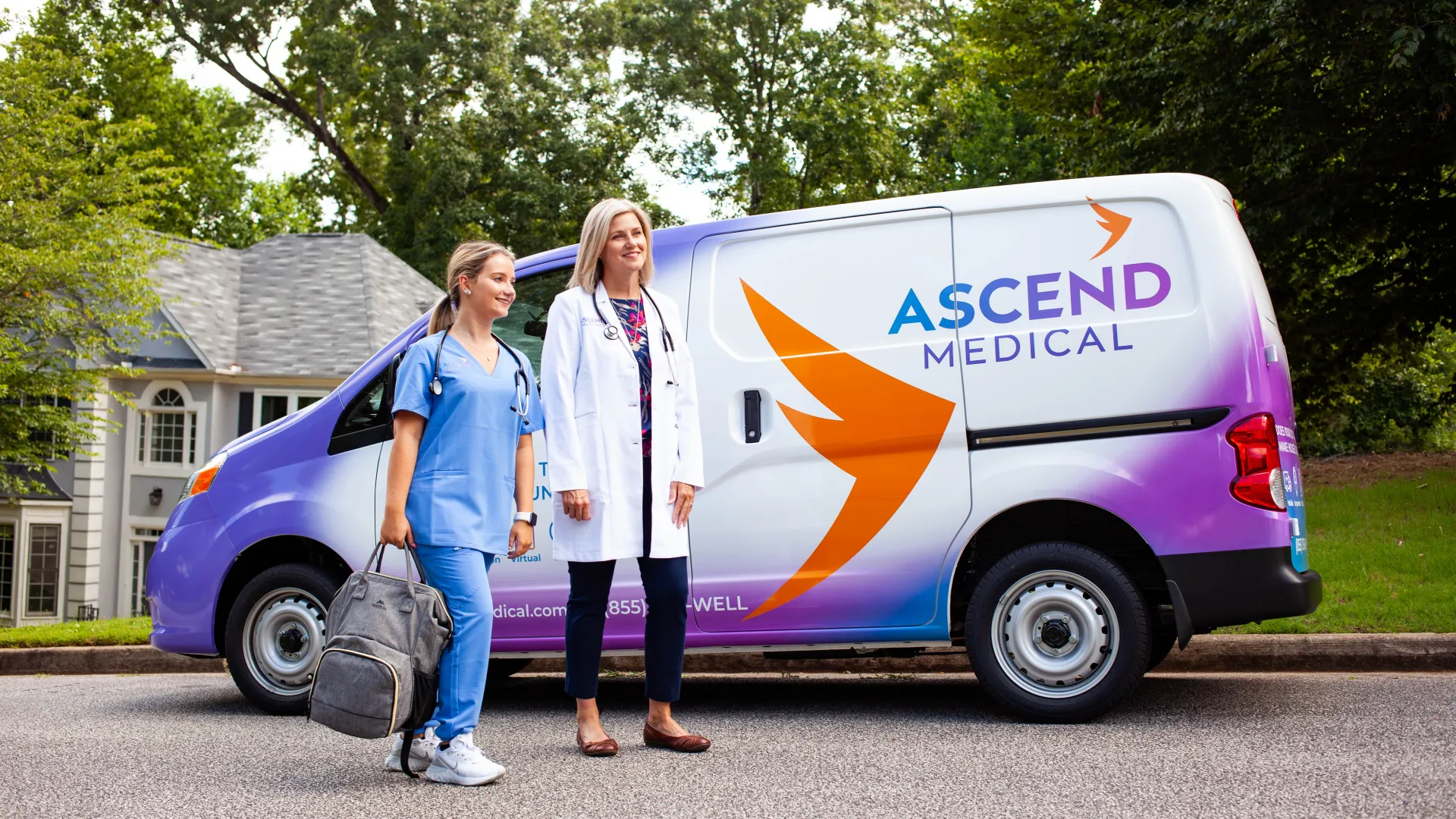 two women standing next to a van