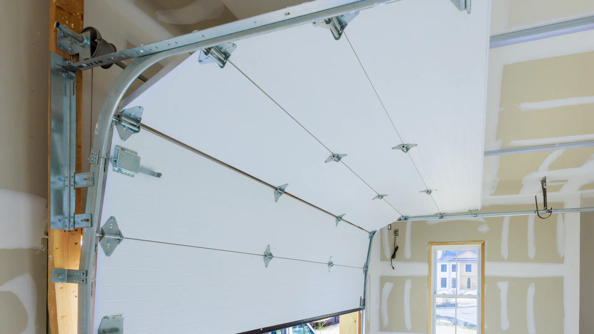 Close-up of a modern garage door mechanism opening in a well-lit garage interior.
