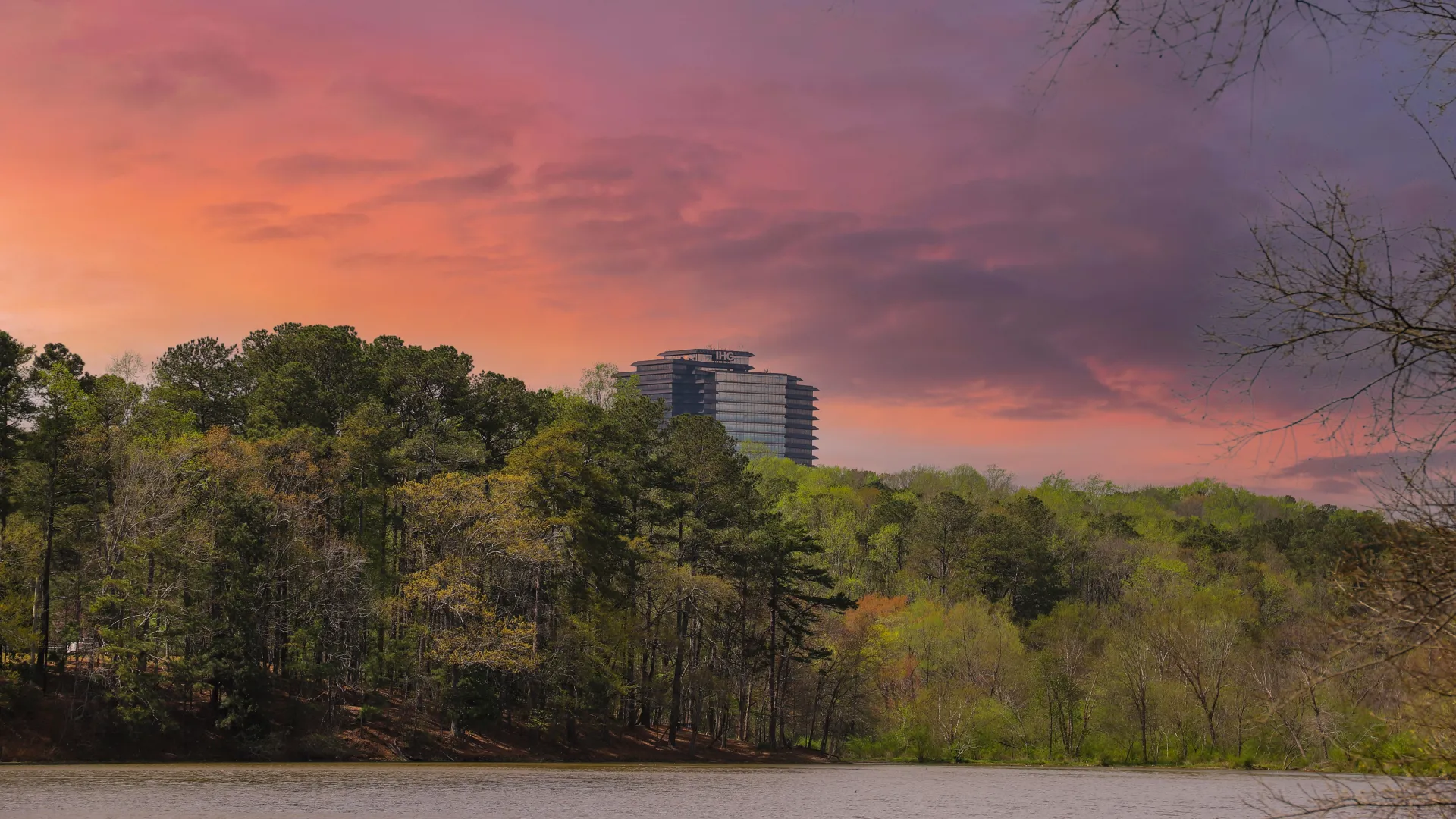 a body of water with trees and a building in the background