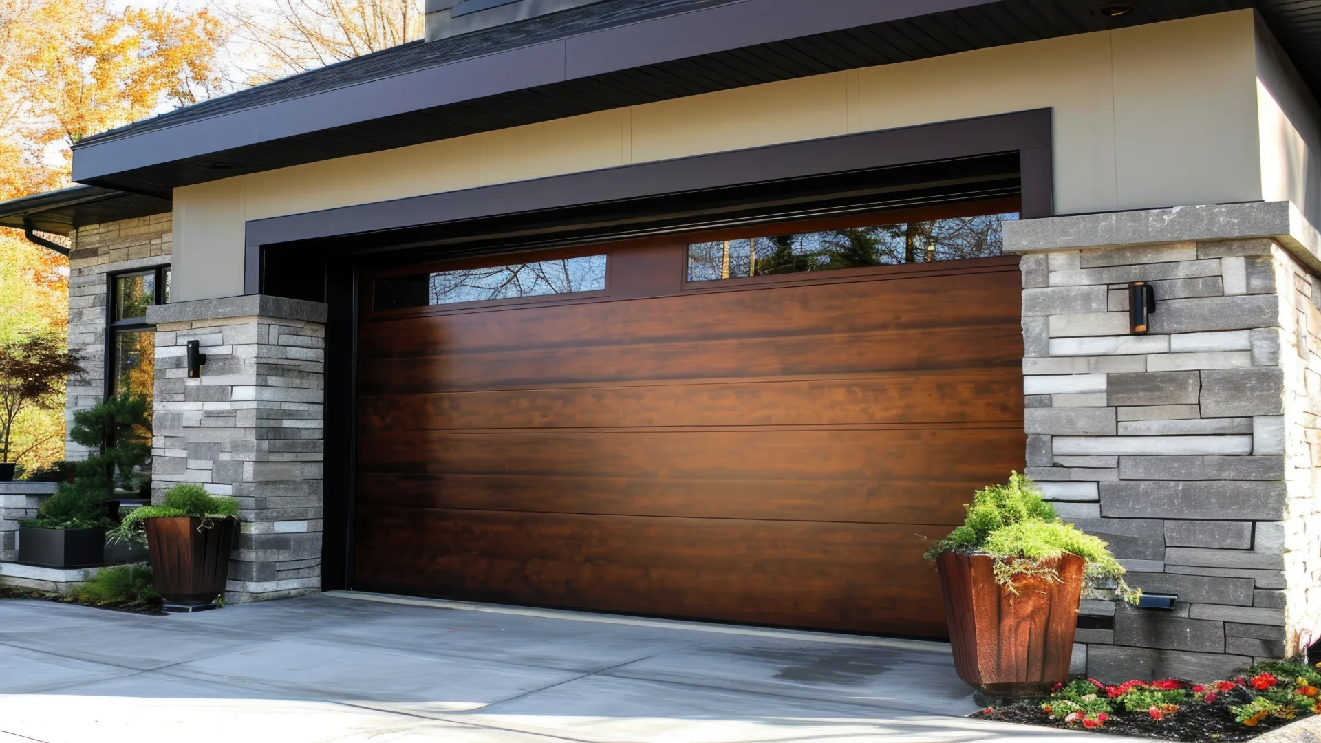 Modern home exterior featuring a wooden garage door and stylish stone accents amidst lush landscaping.