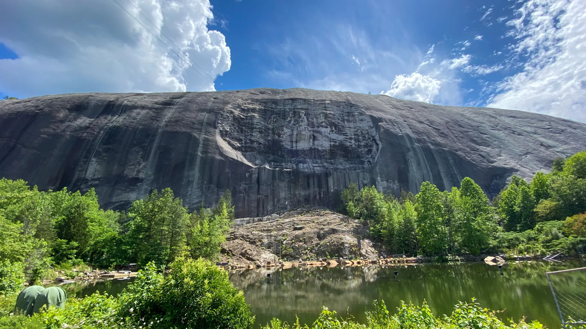 a body of water with trees and mountains in the background