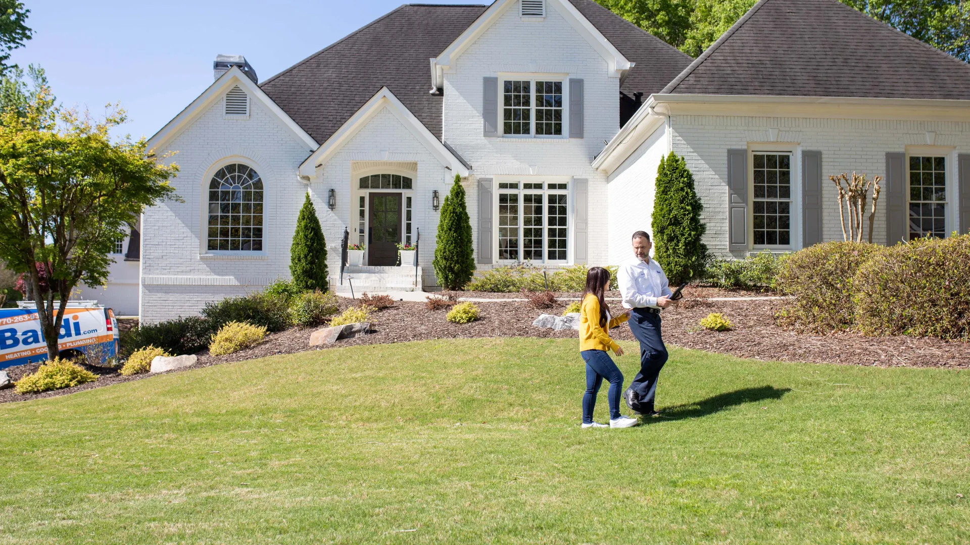 a man and a woman walking in front of a house