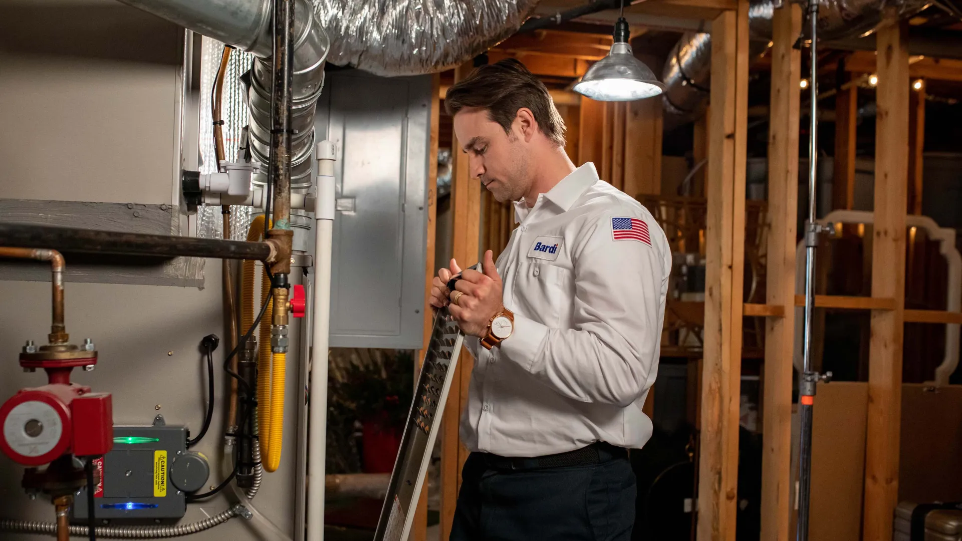 a man working on a furnace in a basement.