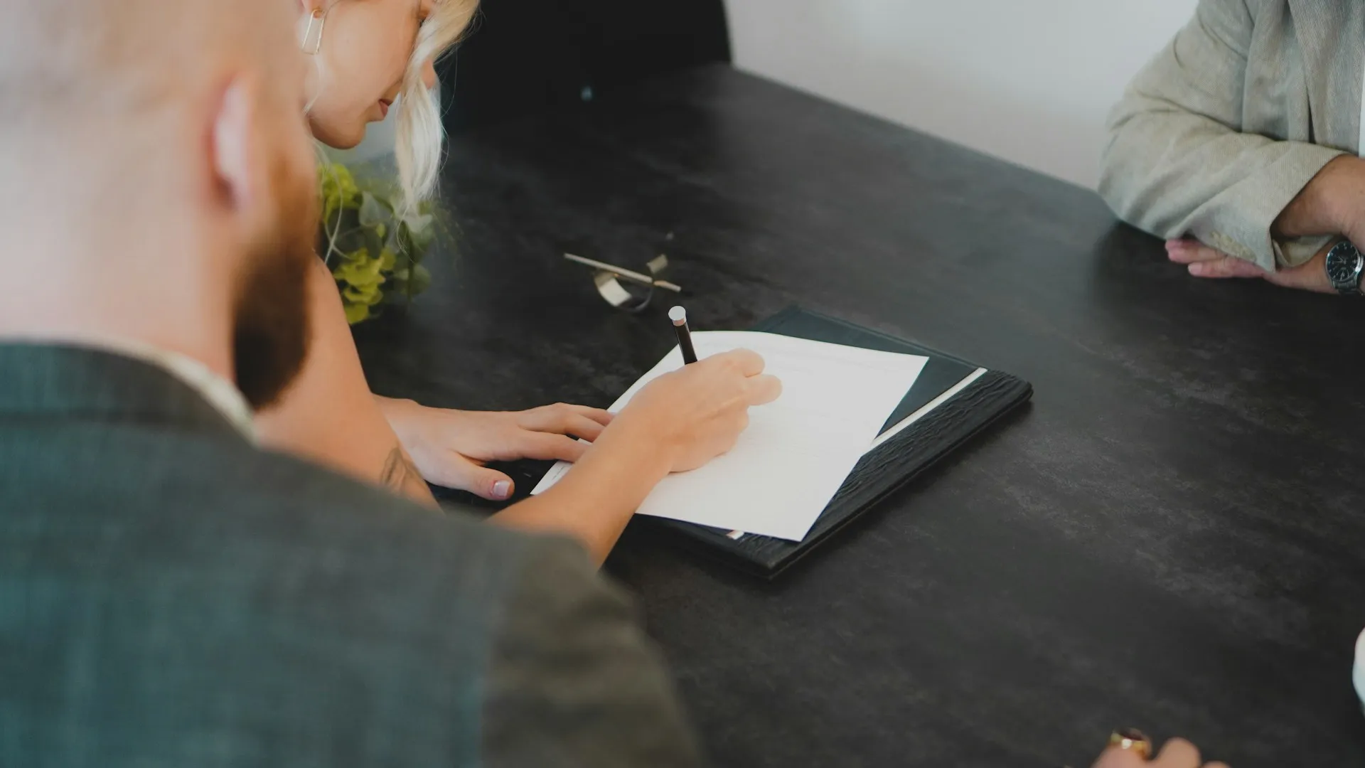 a group of people sitting at a table looking at a book