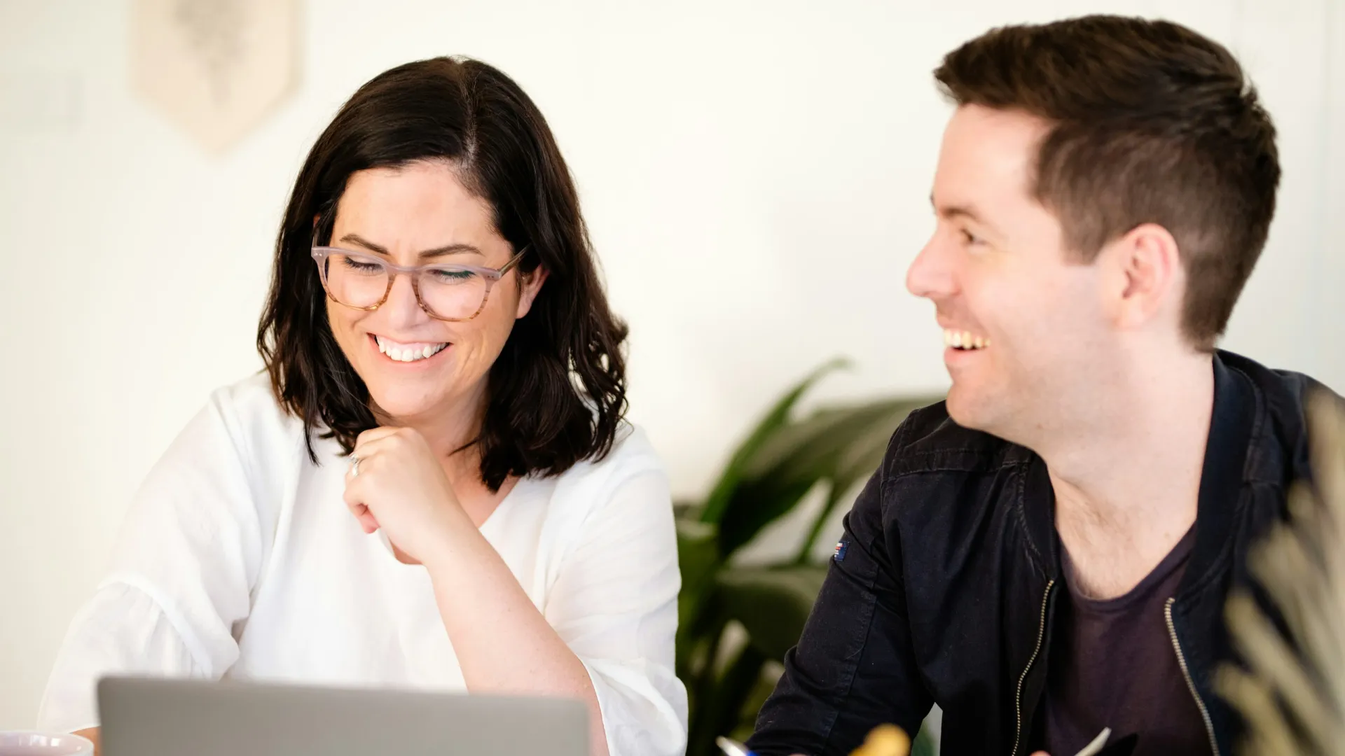 a man and a woman looking at a laptop