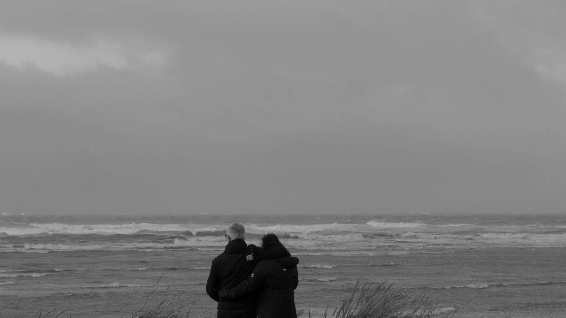 a couple people standing on a beach