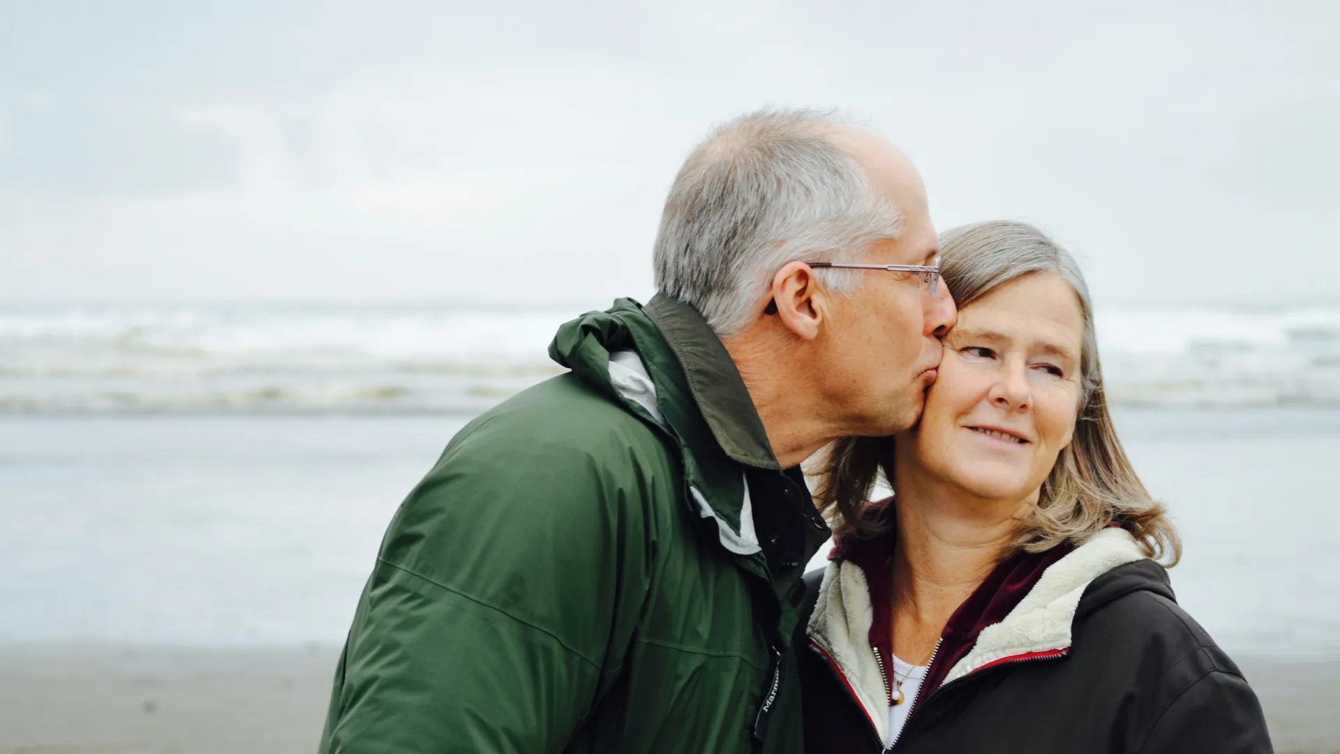 a man kissing a woman on the cheek