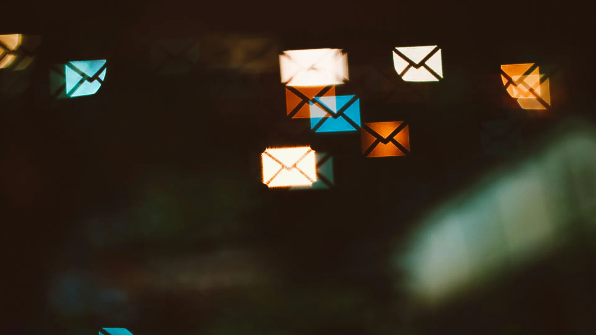 Glowing colorful envelope icons representing email communication on a dark background.
