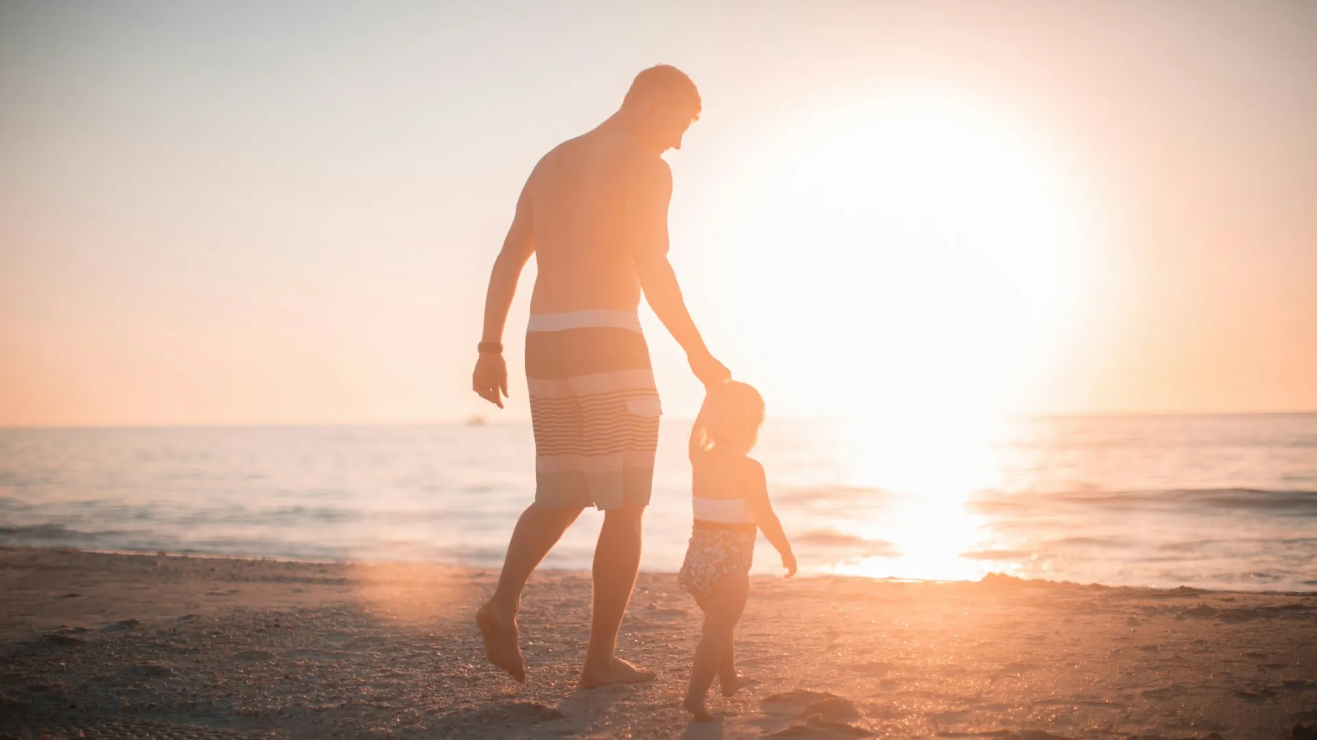 a woman and a child walking on a beach