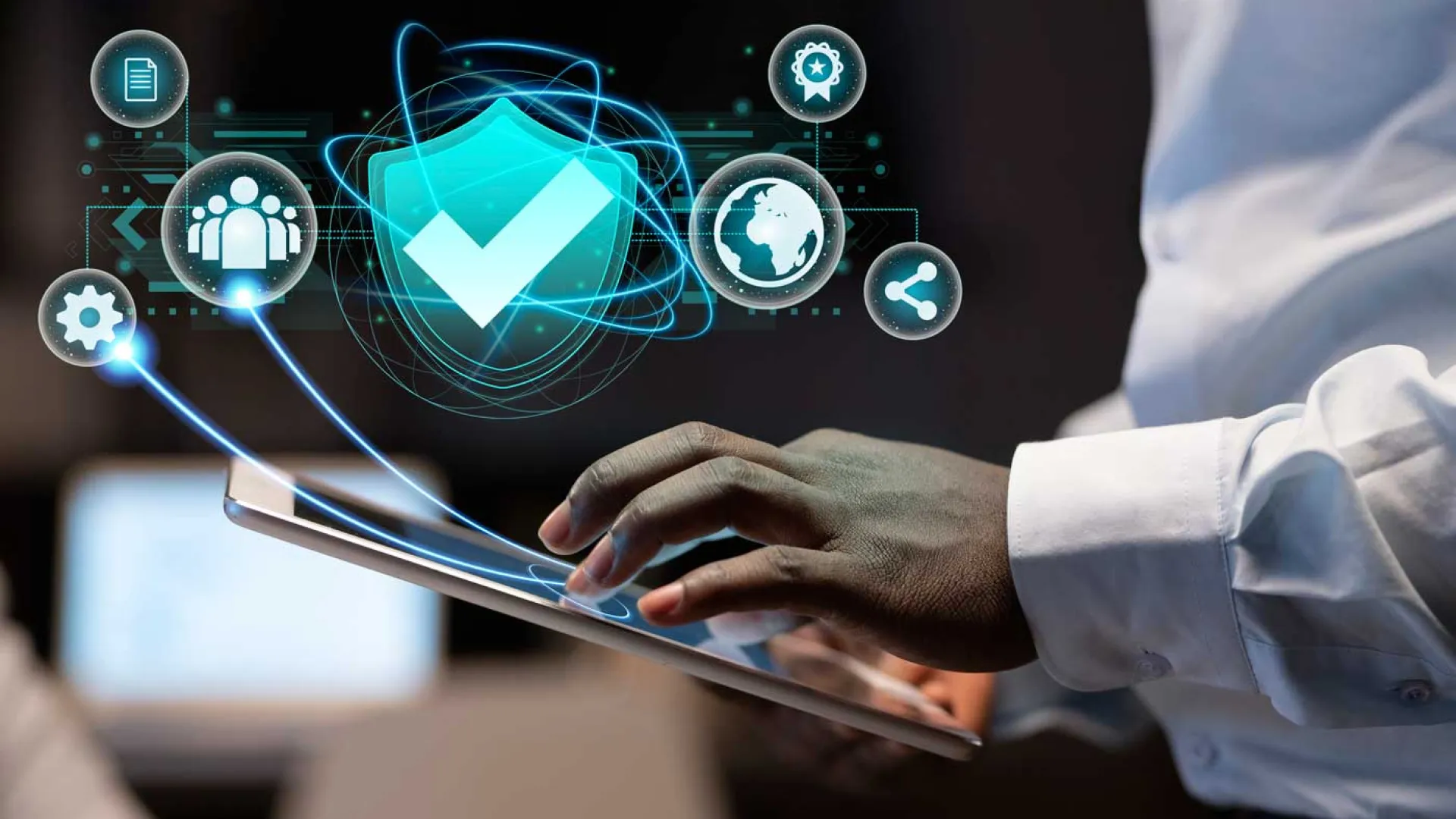 Close-up of a person using a tablet with digital cybersecurity and data protection icons floating above.