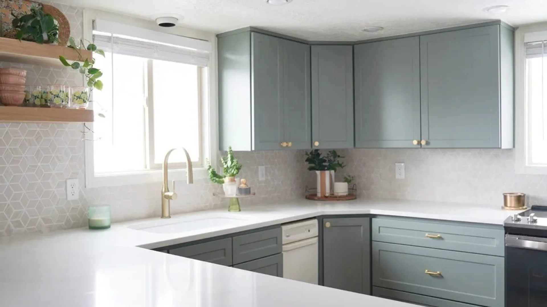 Bright modern kitchen with light gray cabinets, white countertops, gold hardware, and geometric tile backsplash