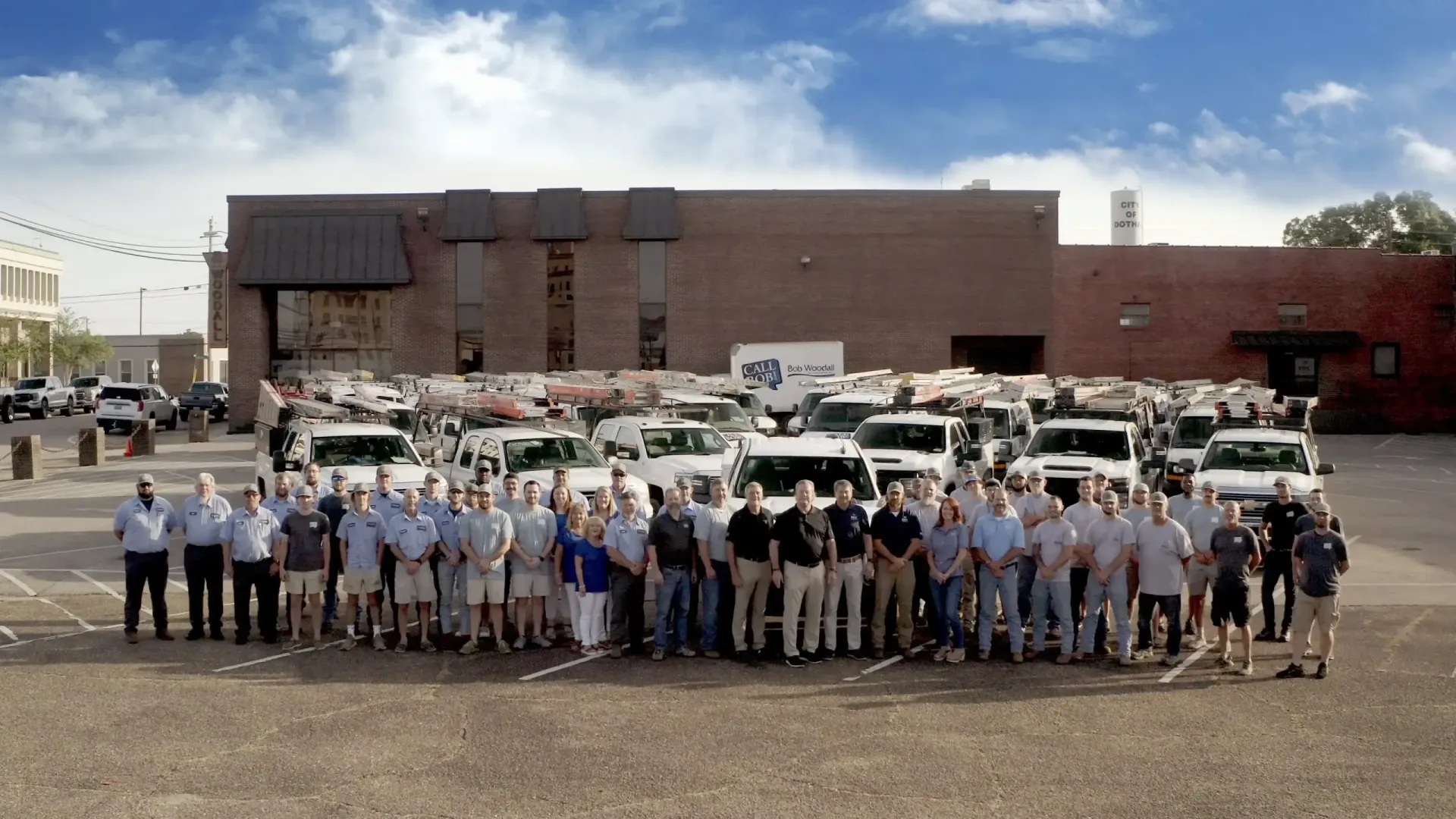 a group of people posing for a photo in front of a building