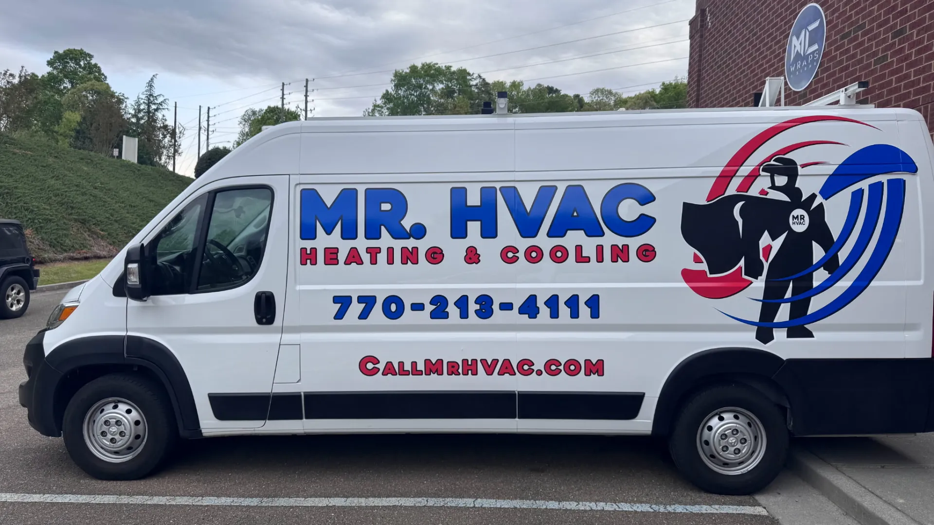 Side view of a white MR. HVAC van featuring bold logo and contact information.