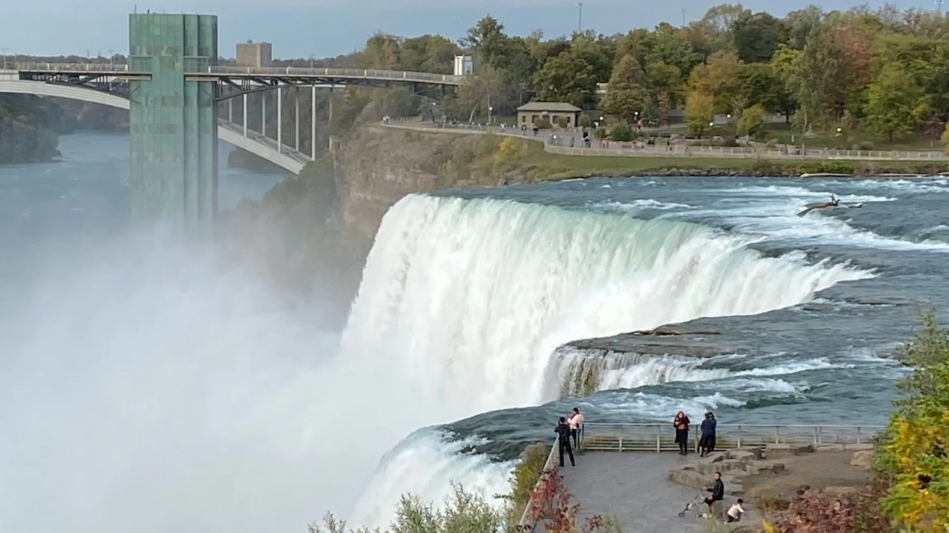a waterfall with people walking on the side