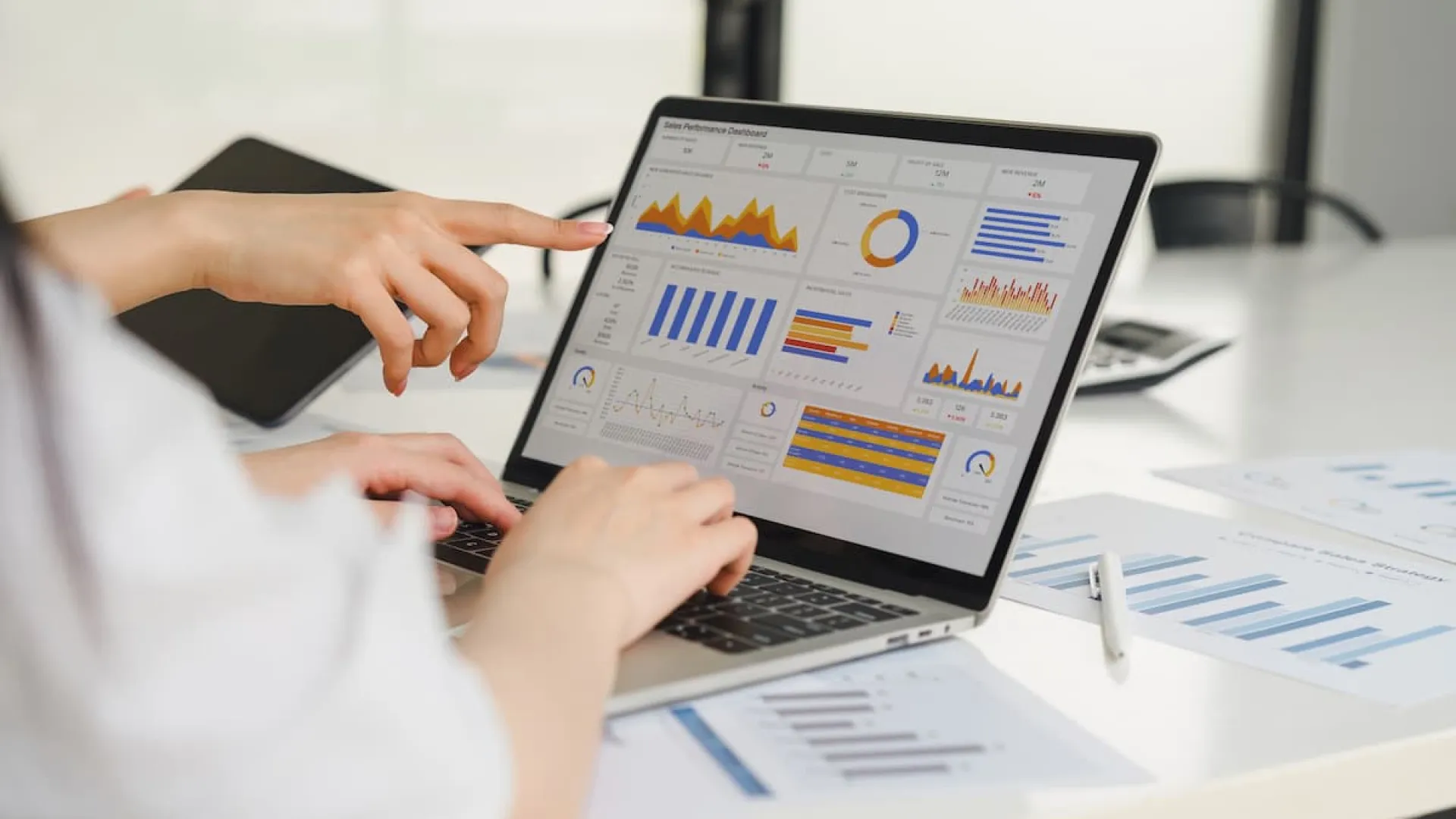 Digital marketing consultants reviewing a sales performance dashboard and data analytics on a laptop to optimize a local business campaign.