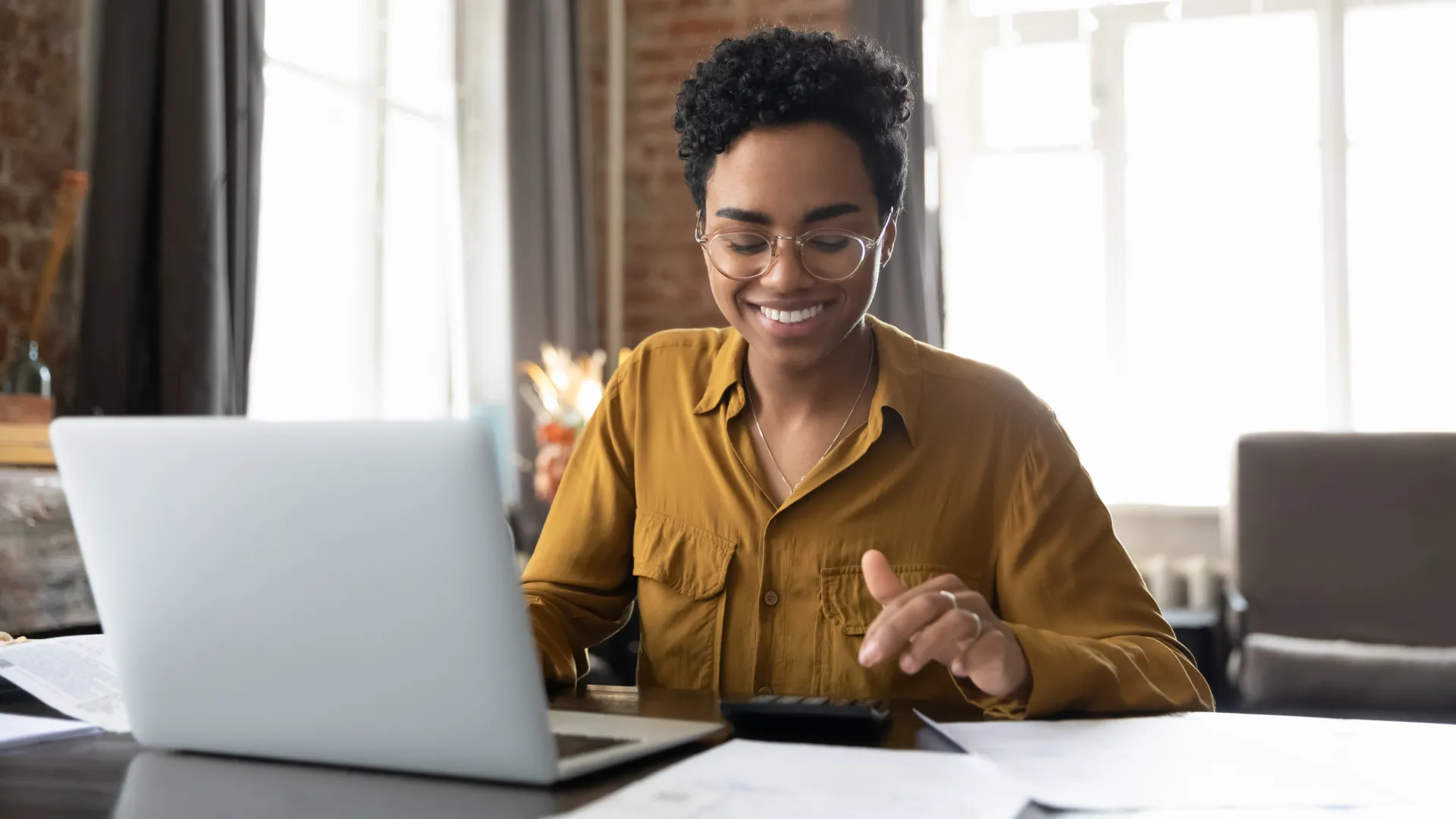 a person sitting at a table with a laptop and calculator